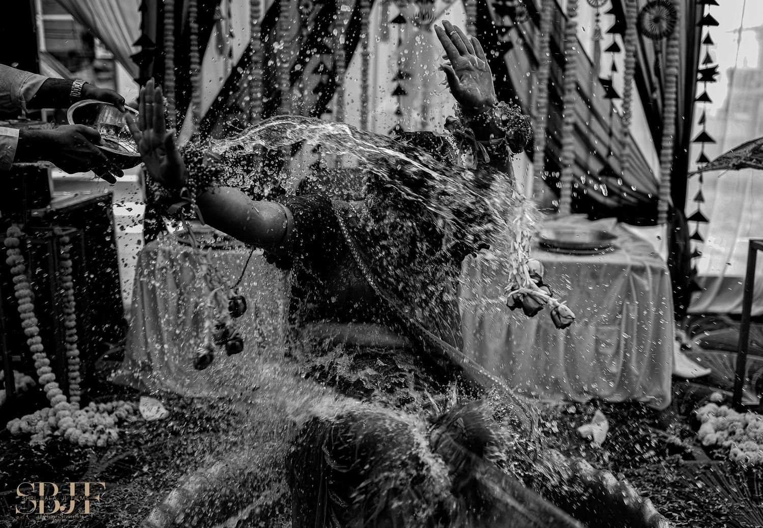 A dramatic black and white photograph of water splashing and spraying in a high-energy action shot.