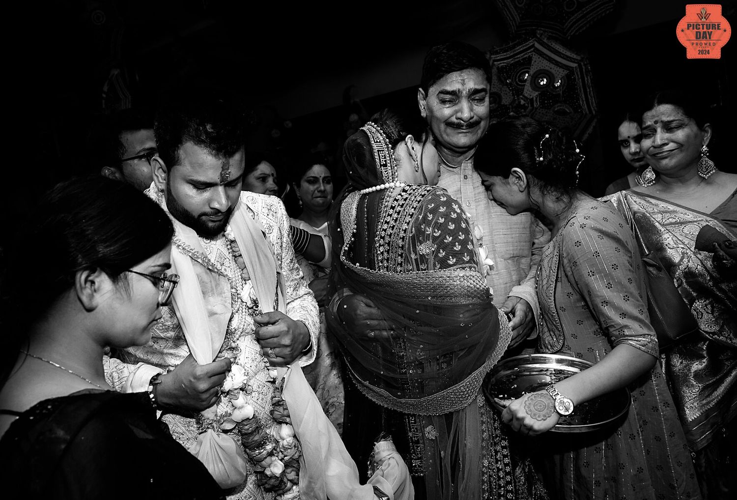 Black and white candid shot of group celebration with traditional Indian attire.