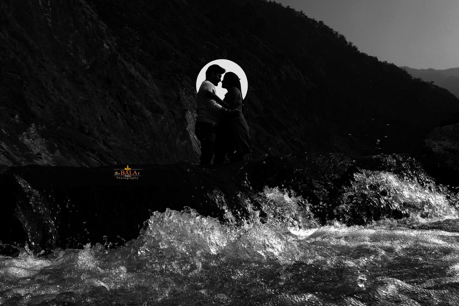 Dramatic black and white coastal landscape with waves crashing against rugged cliffs.