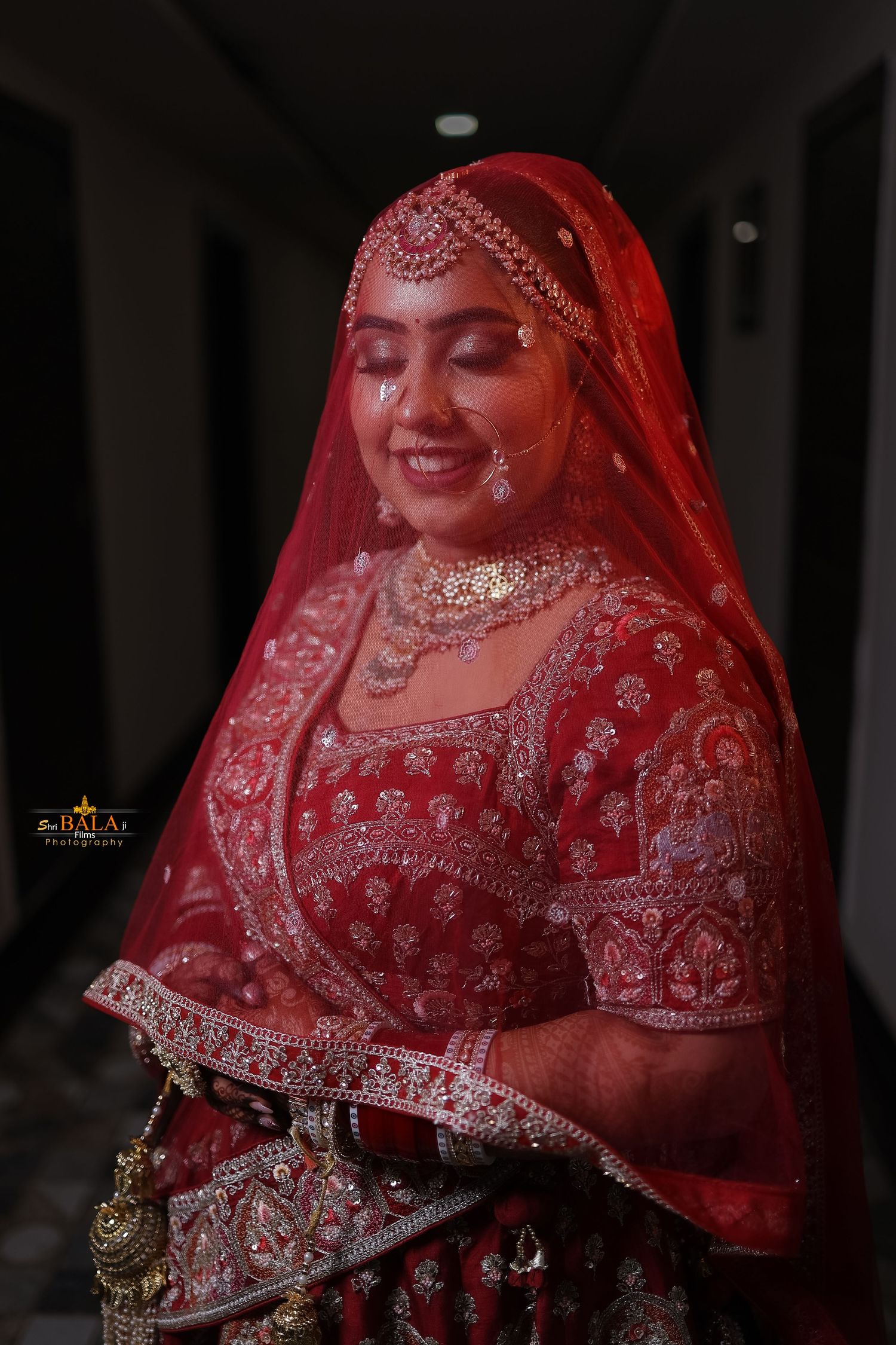 Traditional Indian bride in red lehenga with intricate embellishments.