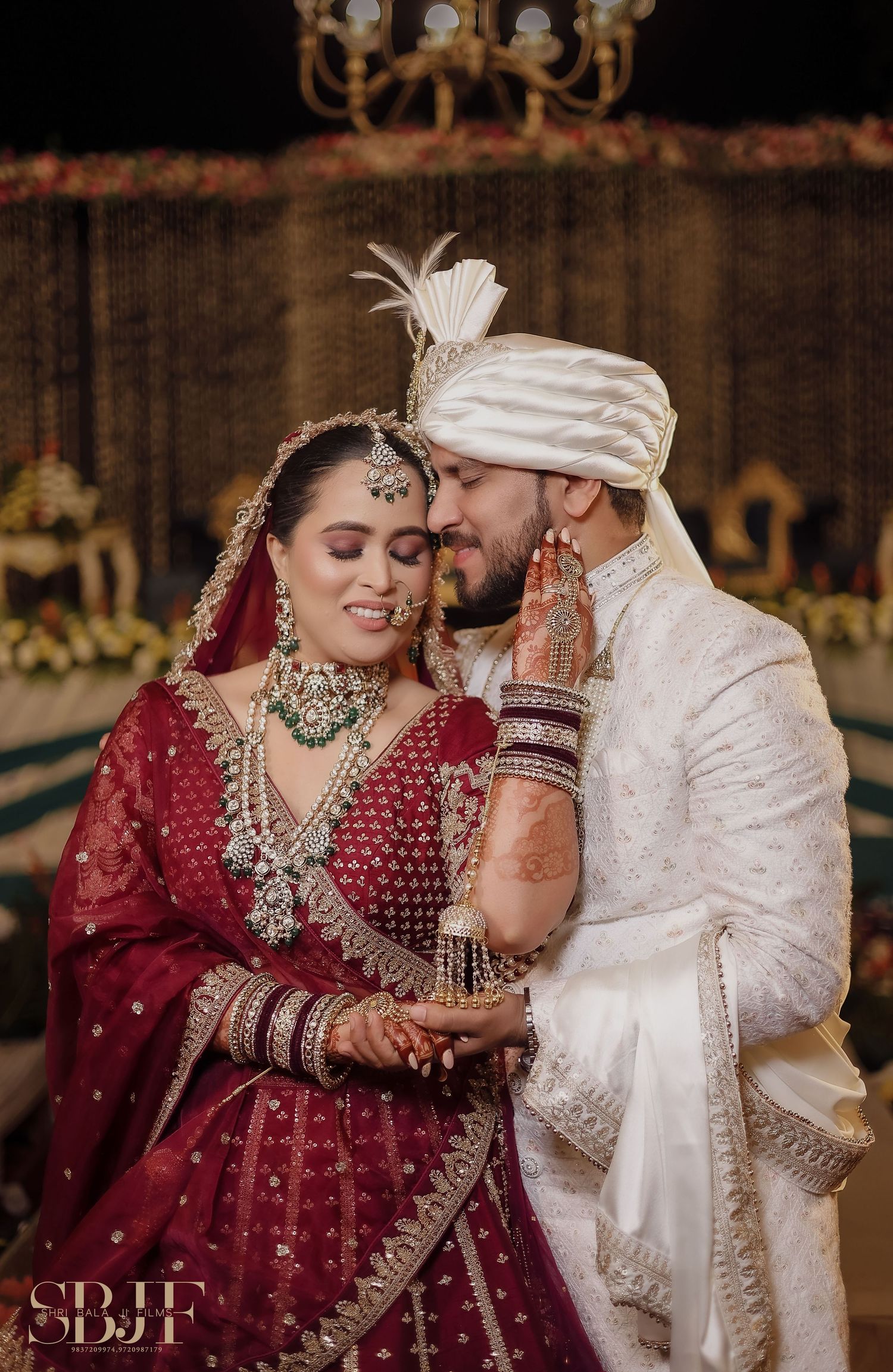 A couple in traditional Indian wedding attire share intimate moments during their wedding ceremony.