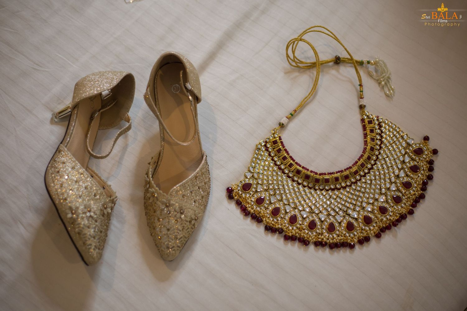 Wedding accessories featuring sparkly pointed-toe flats and an ornate gold necklace.
