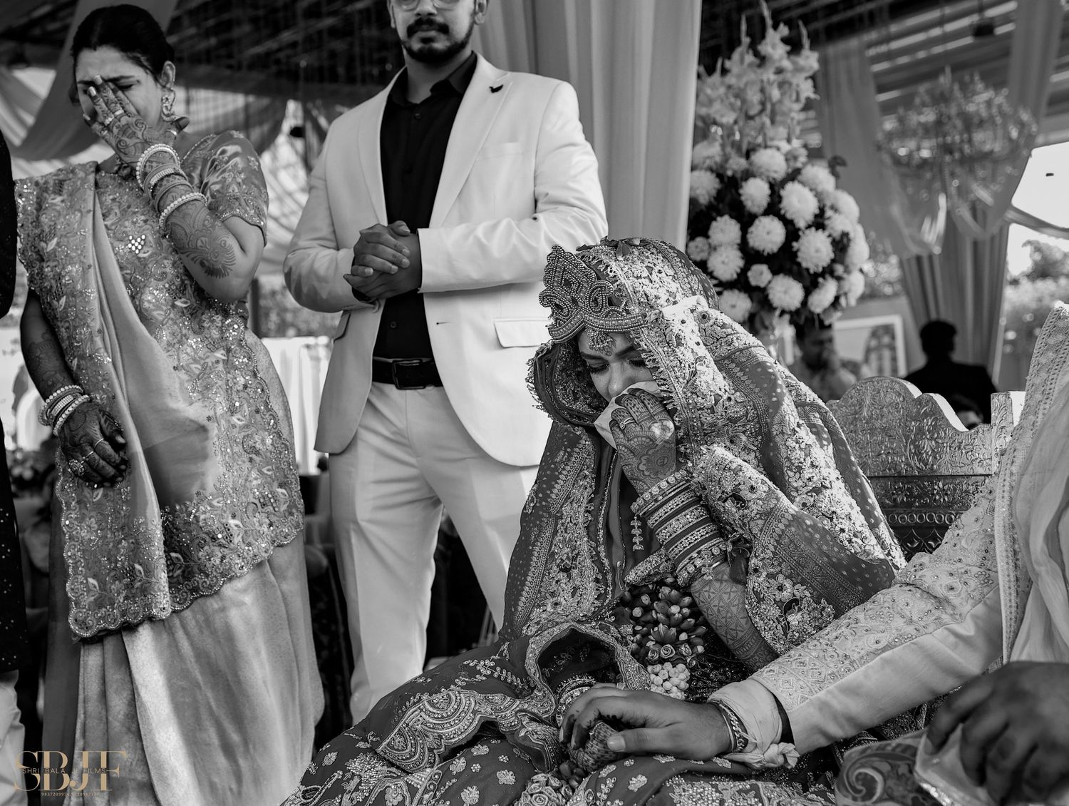 Black and white photo of an Indian bride in ornate bridal attire during a traditional Hindu wedding ceremony.