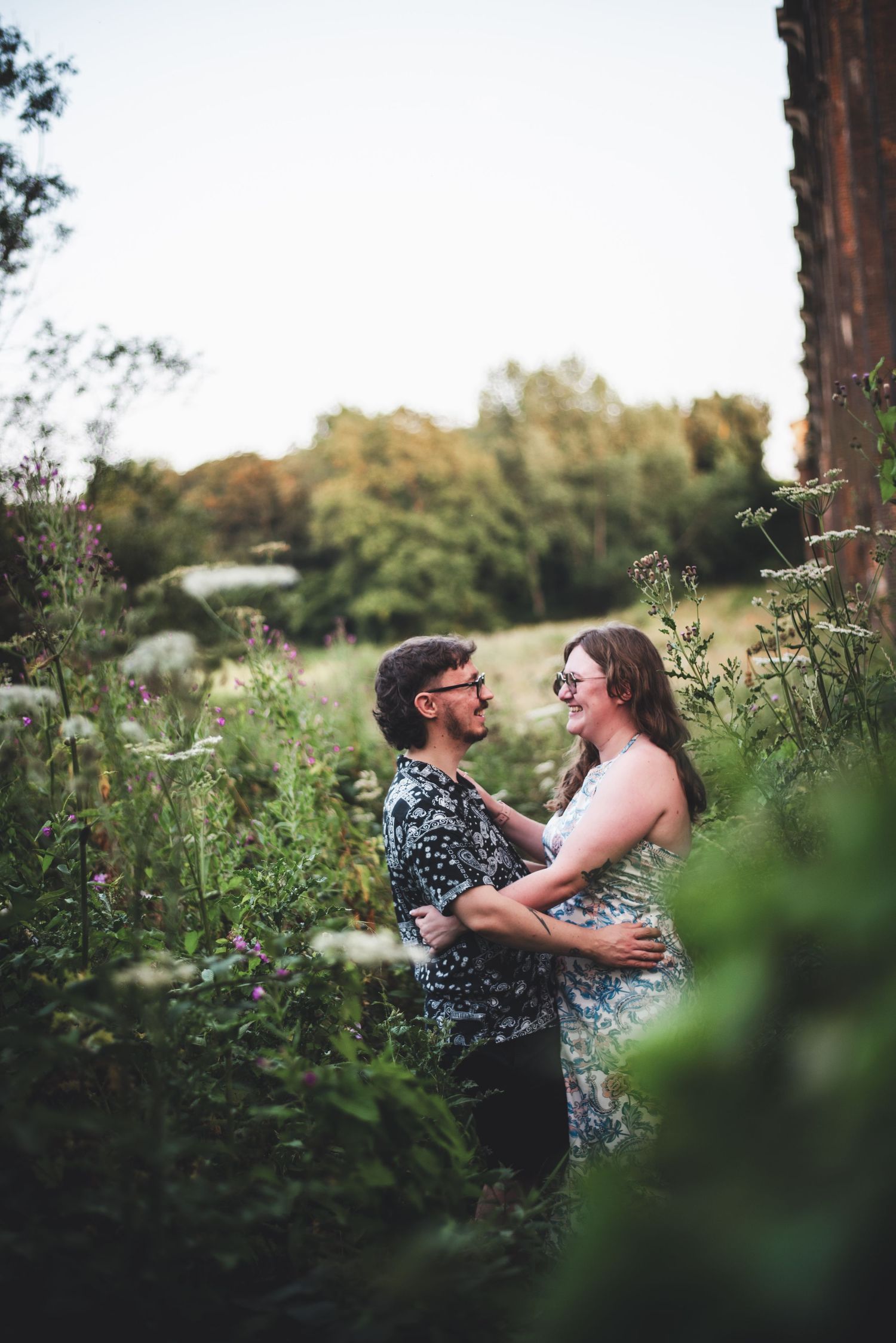 A couple shares an intimate moment among wildflowers in a summer meadow.