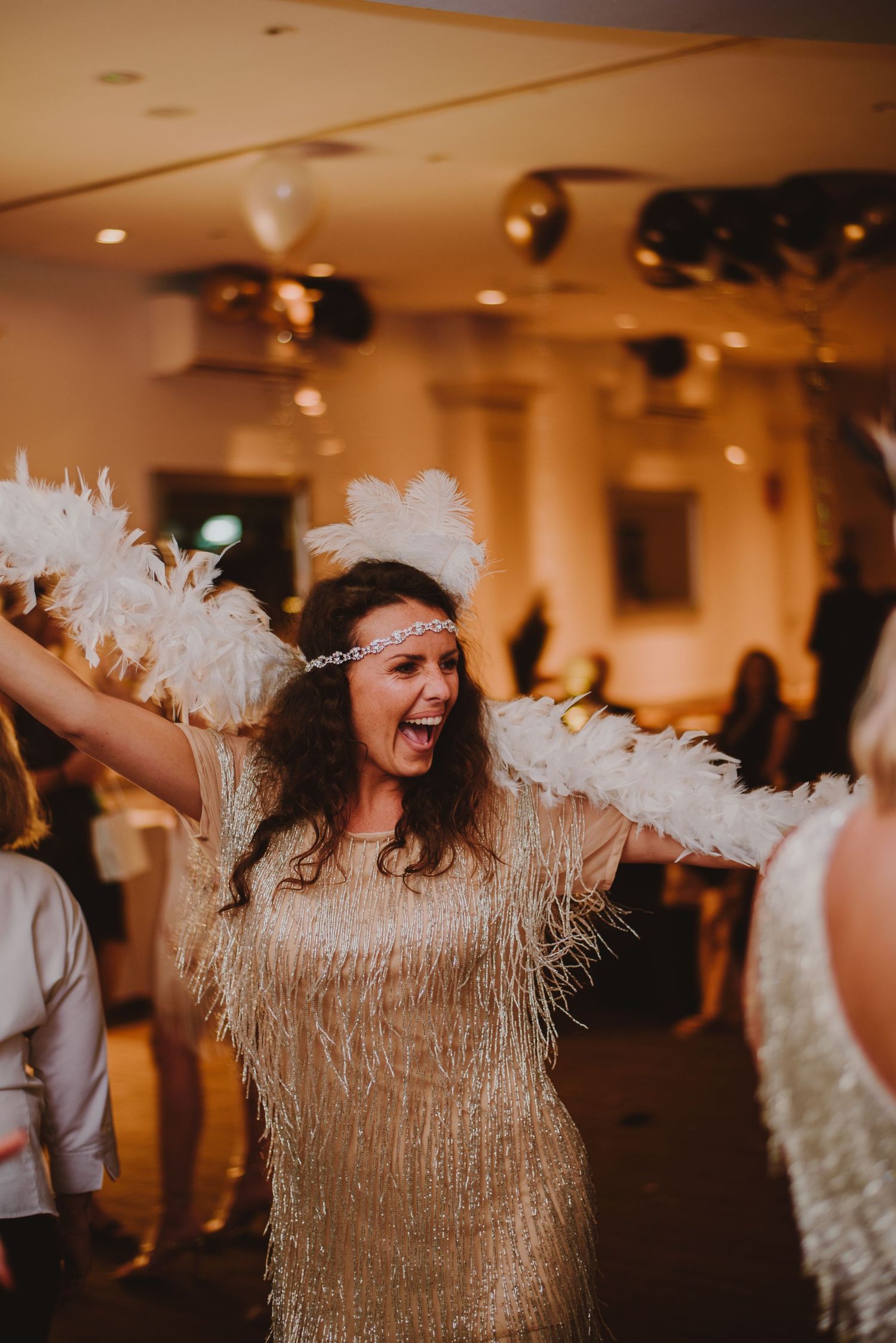 Energetic dance celebration with gold fringe costumes in warm lighting.