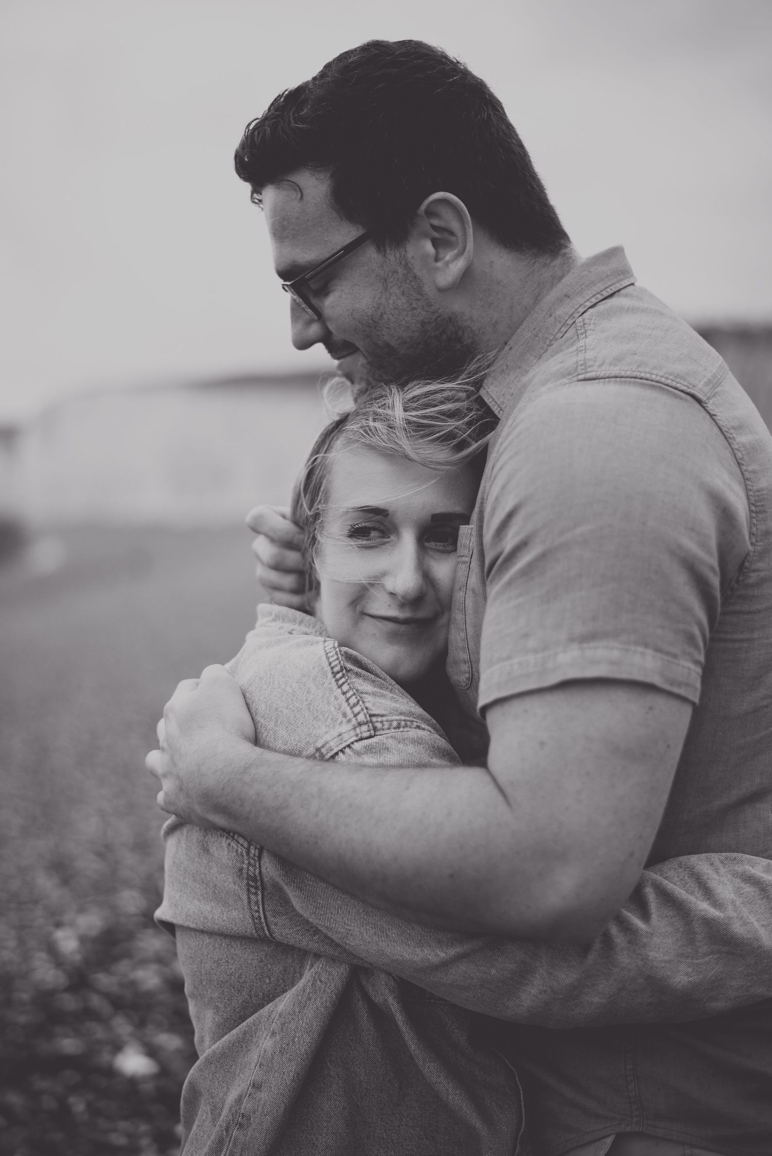 A tender embrace captured in black and white photography outdoors.