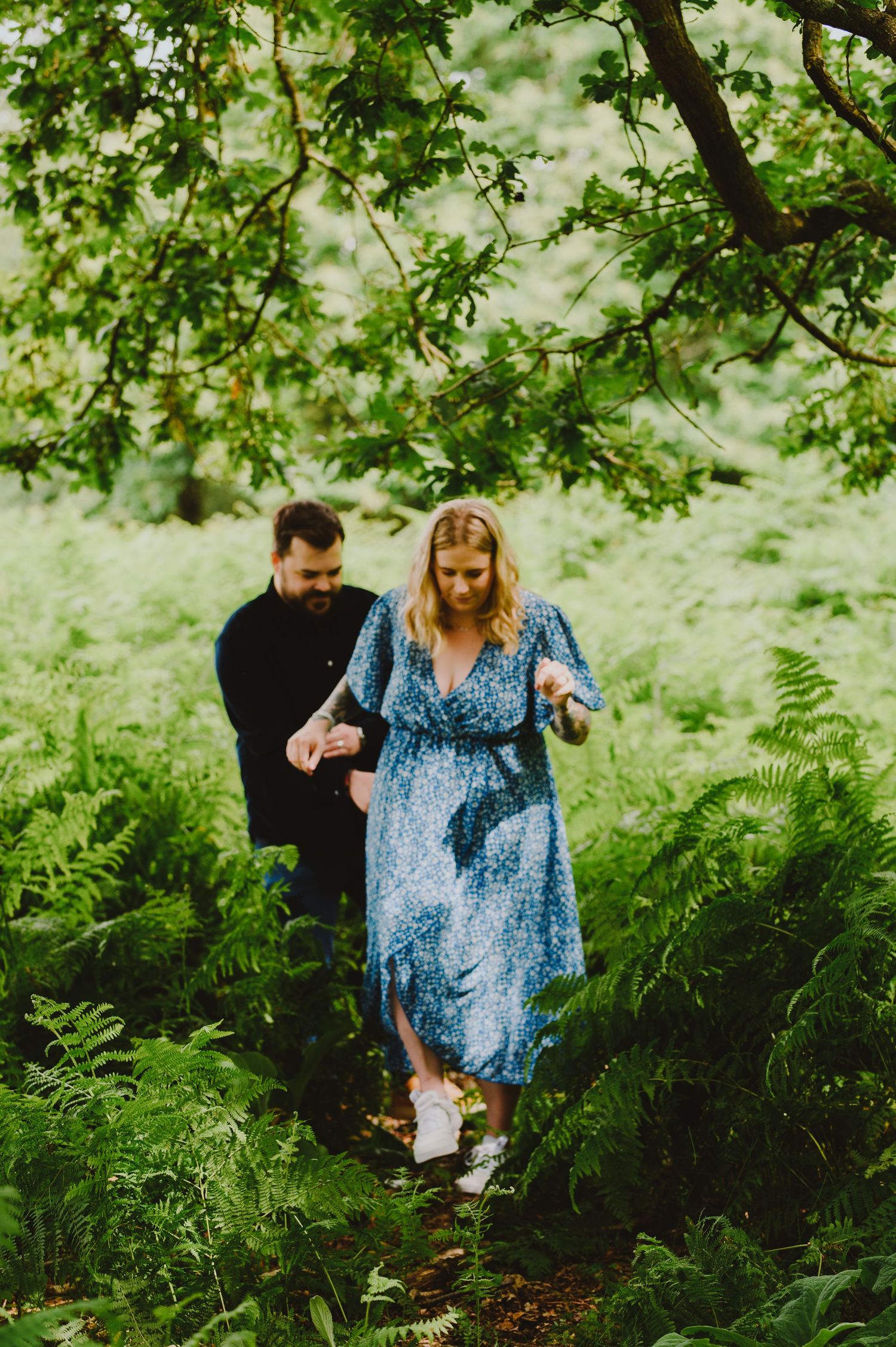 Four sequential photos show a couple walking through lush green forest ferns in a romantic woodland setting.