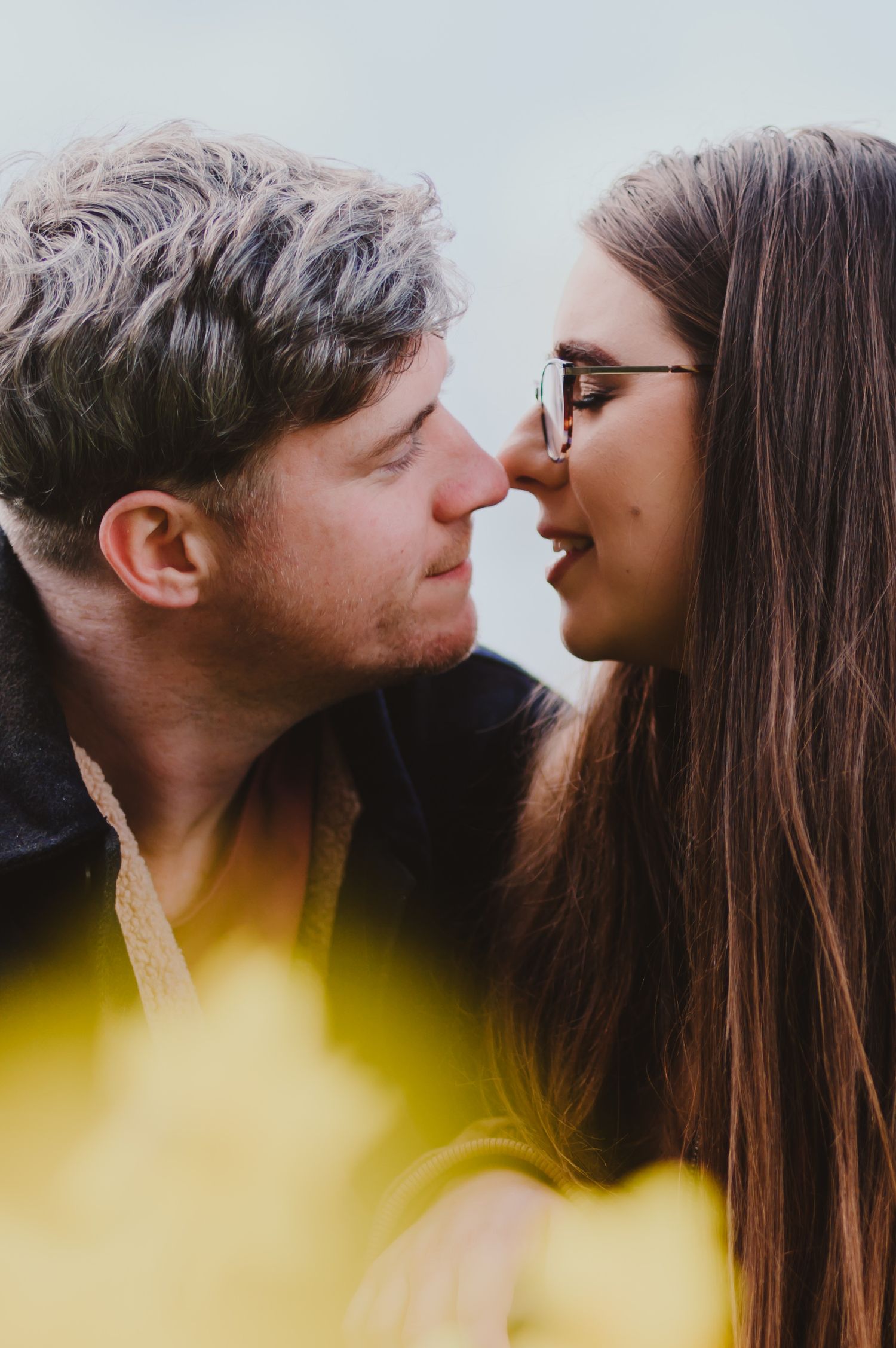 A romantic couple sharing intimate moments in a series of close-up profile shots against a blurred yellow background.