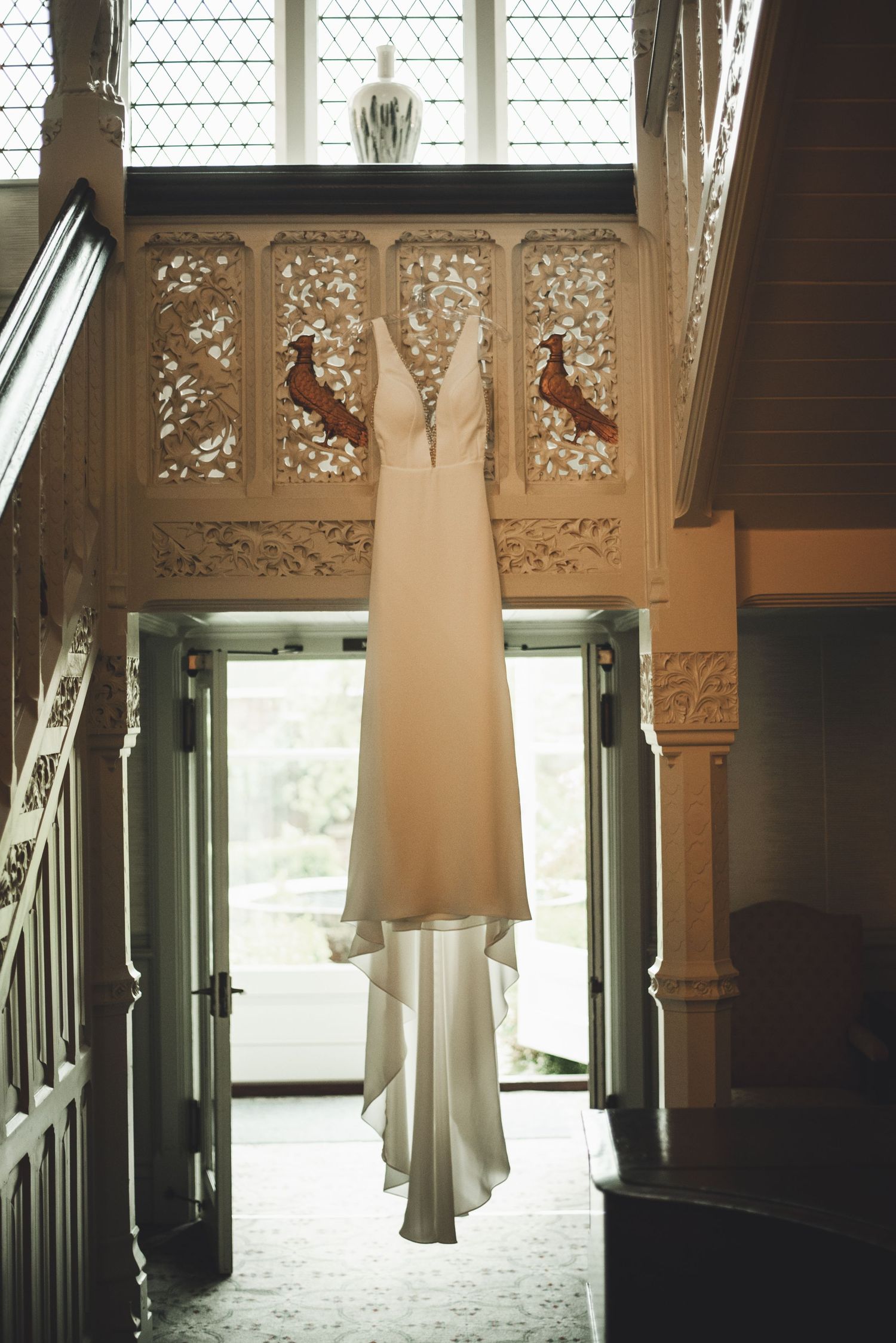 Decorative wooden panels and lace-like architectural details create an elegant interior hallway with natural light streaming in.