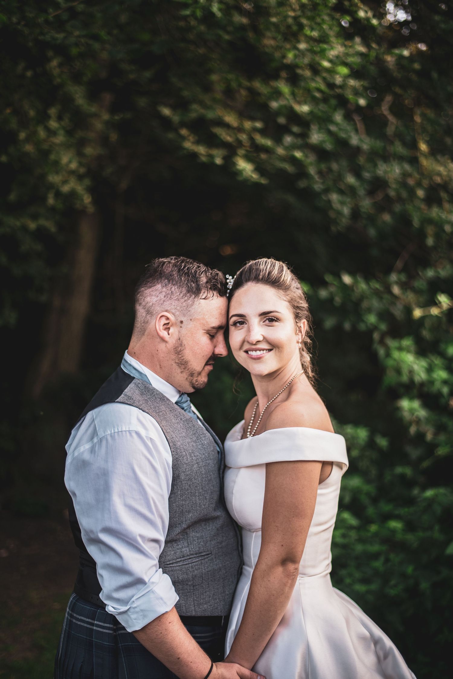 Kent Wedding.Romantic couple shares intimate wedding photos in an outdoor garden setting with natural lighting.