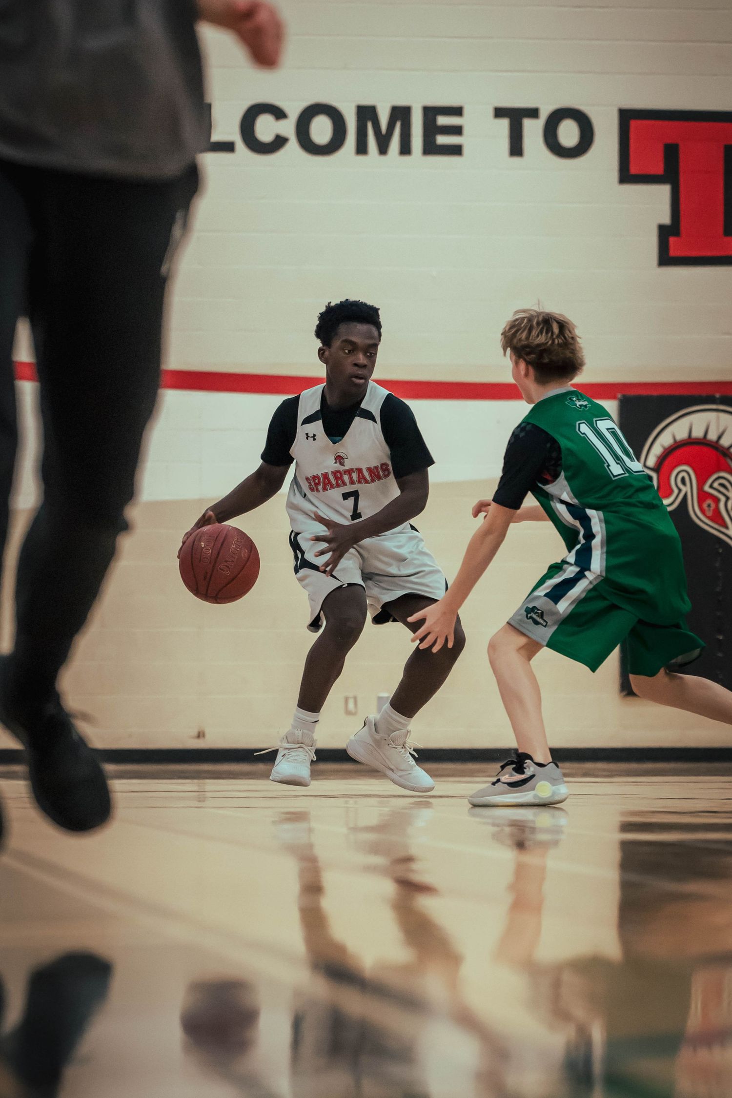 Players in green and white uniforms navigate the court during an intense basketball match.