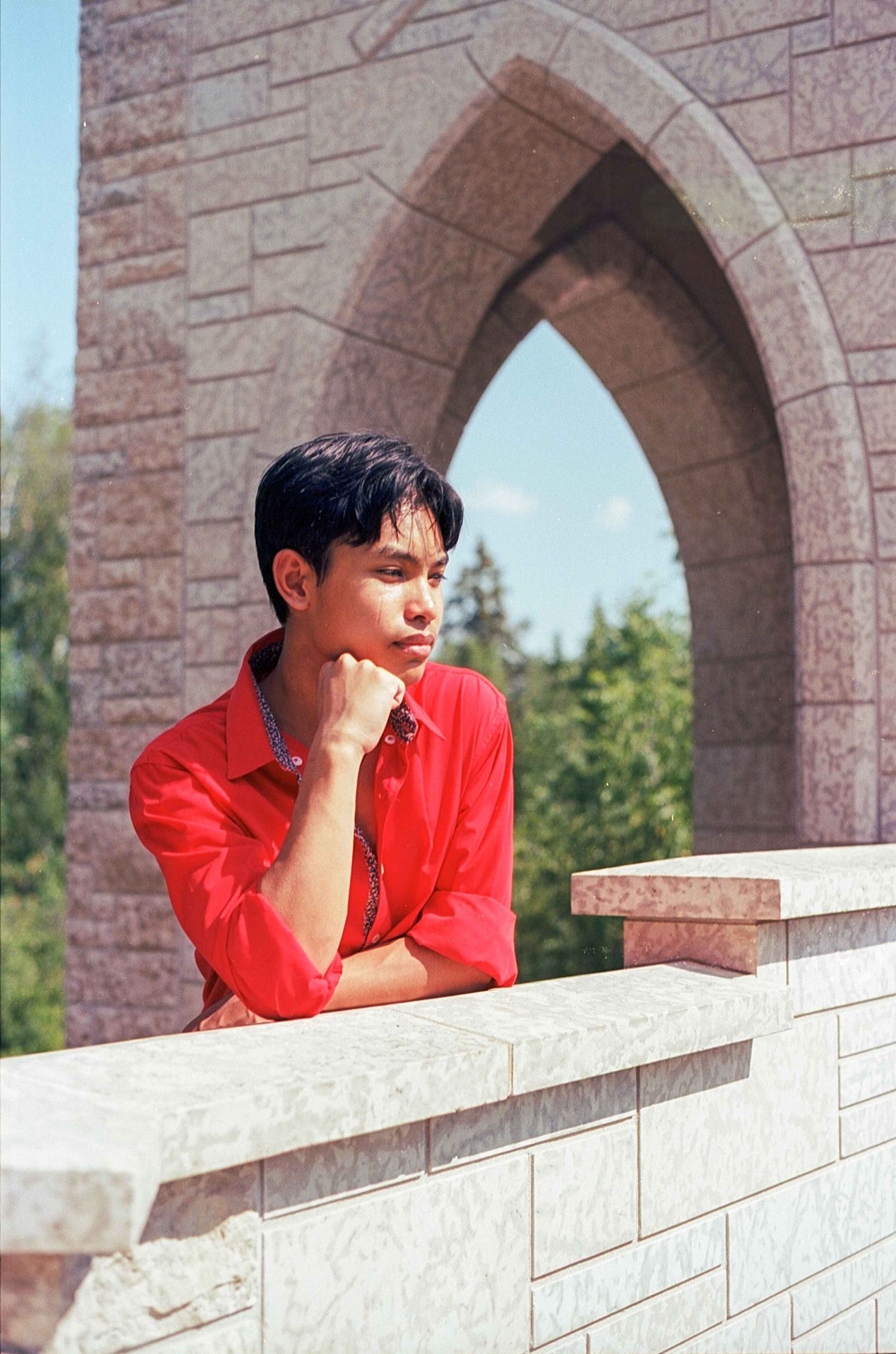 Stone archways frame a contemplative scene against a sunny outdoor background.