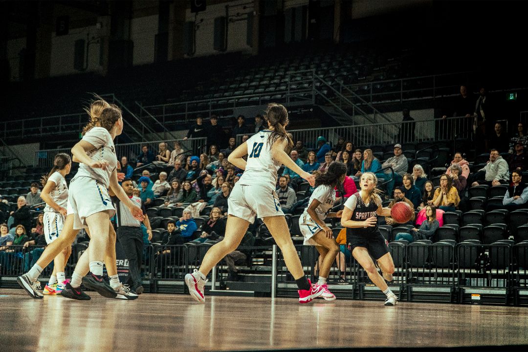 Women's basketball players in action during an intense game moment on the court.
