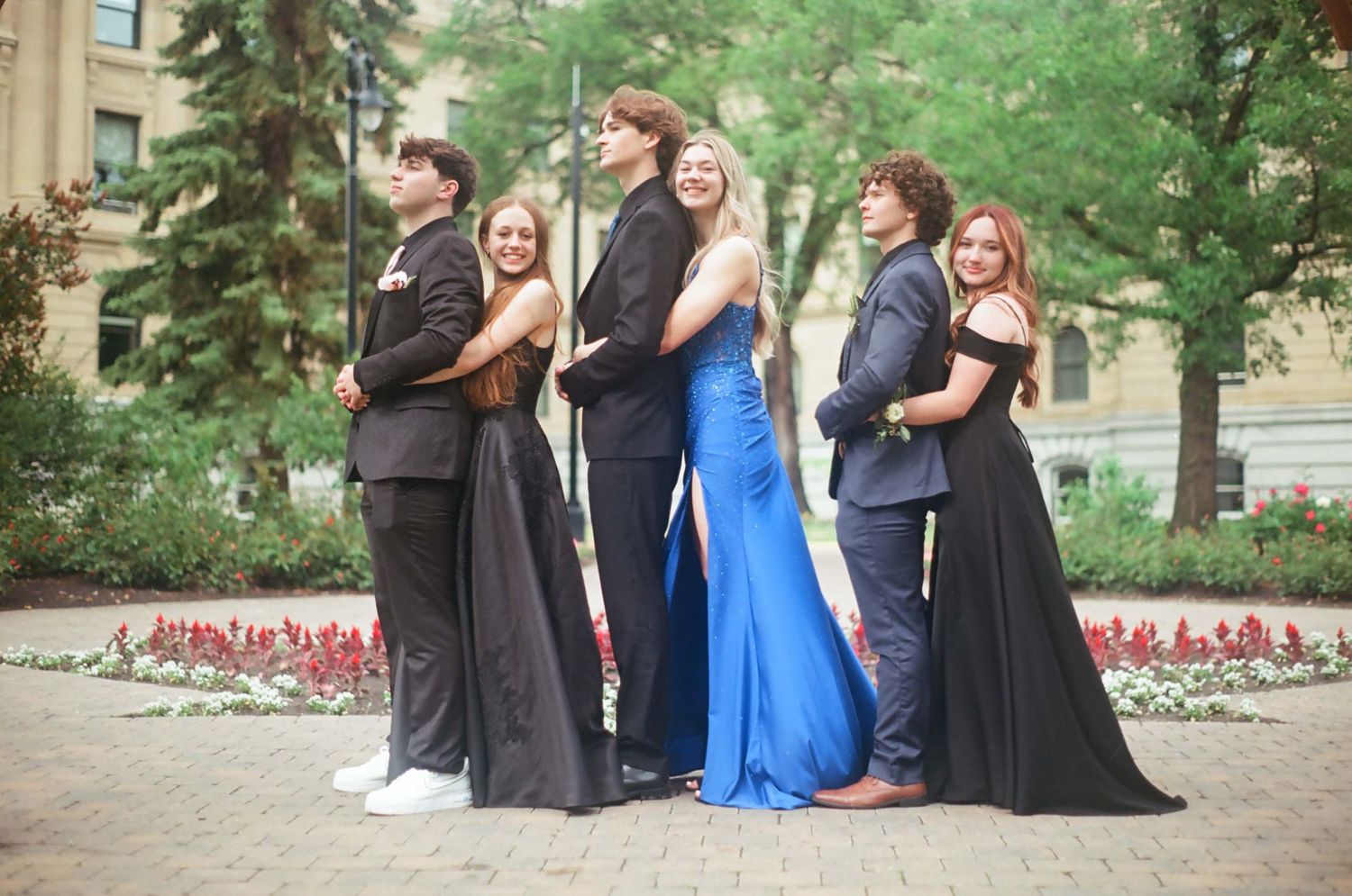 Formal group poses together outdoors in elegant attire.