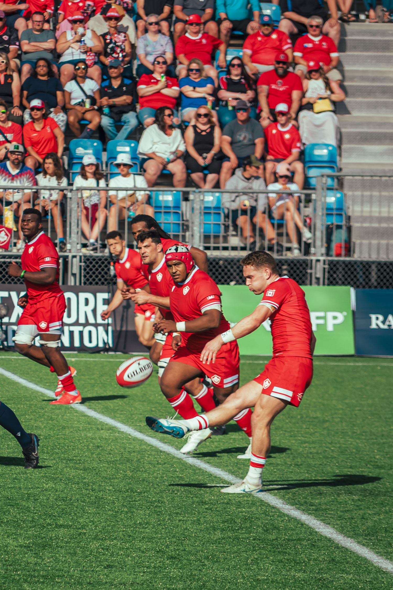 Rugby team players stretch and warm up on the sideline before a match.
