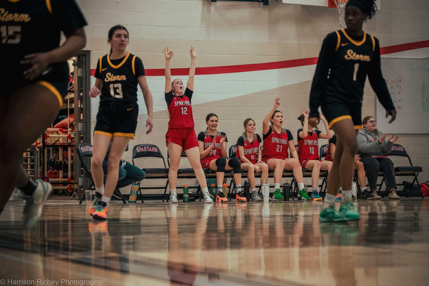 Athletes compete in an indoor sports match with spectators watching from the sidelines.