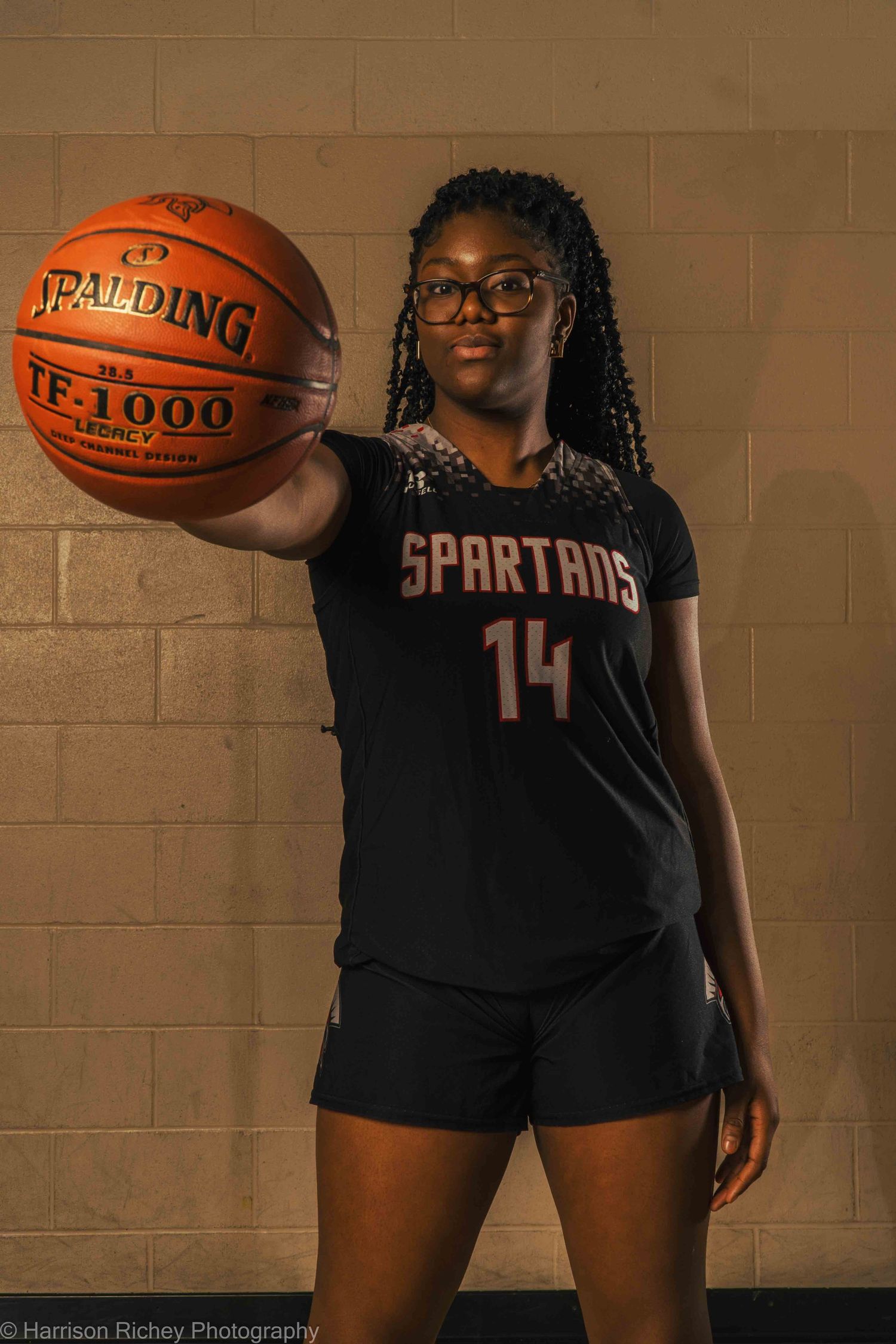 Basketball player in Spartans uniform demonstrates ball handling poses.
