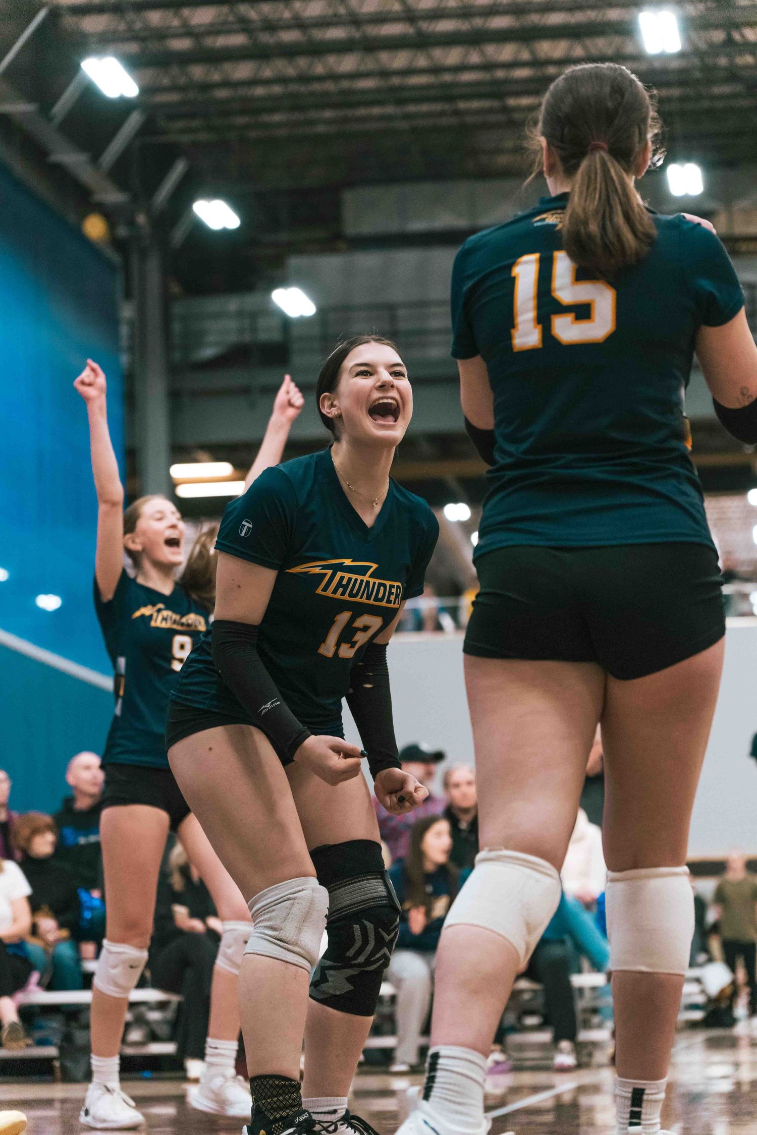Volleyball team celebrates point scored during indoor match.