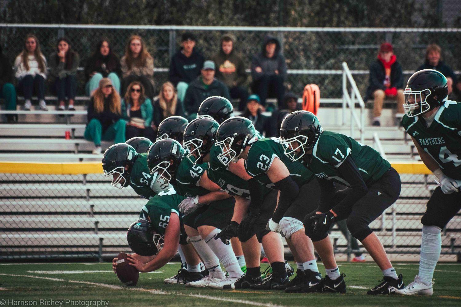 Football team lines up in offensive formation on field during game.