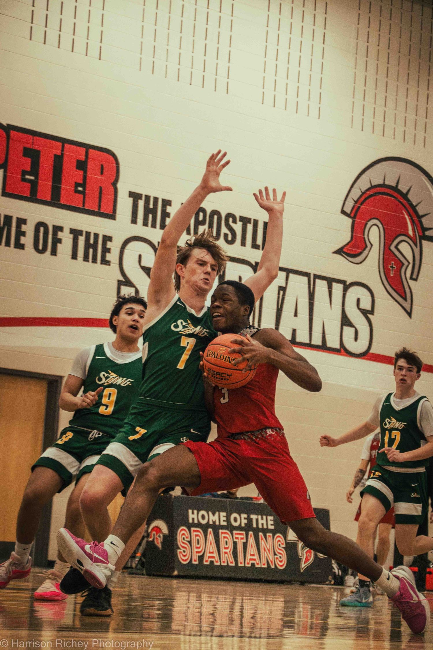 Players in green and red uniforms battle for possession during an intense basketball game.