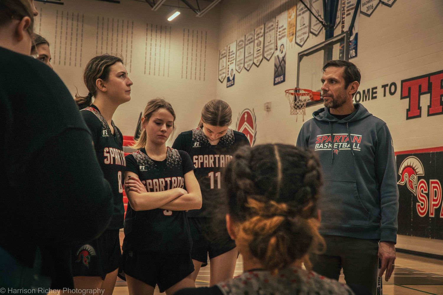 Spectators and players gather in a gymnasium during a youth basketball event.