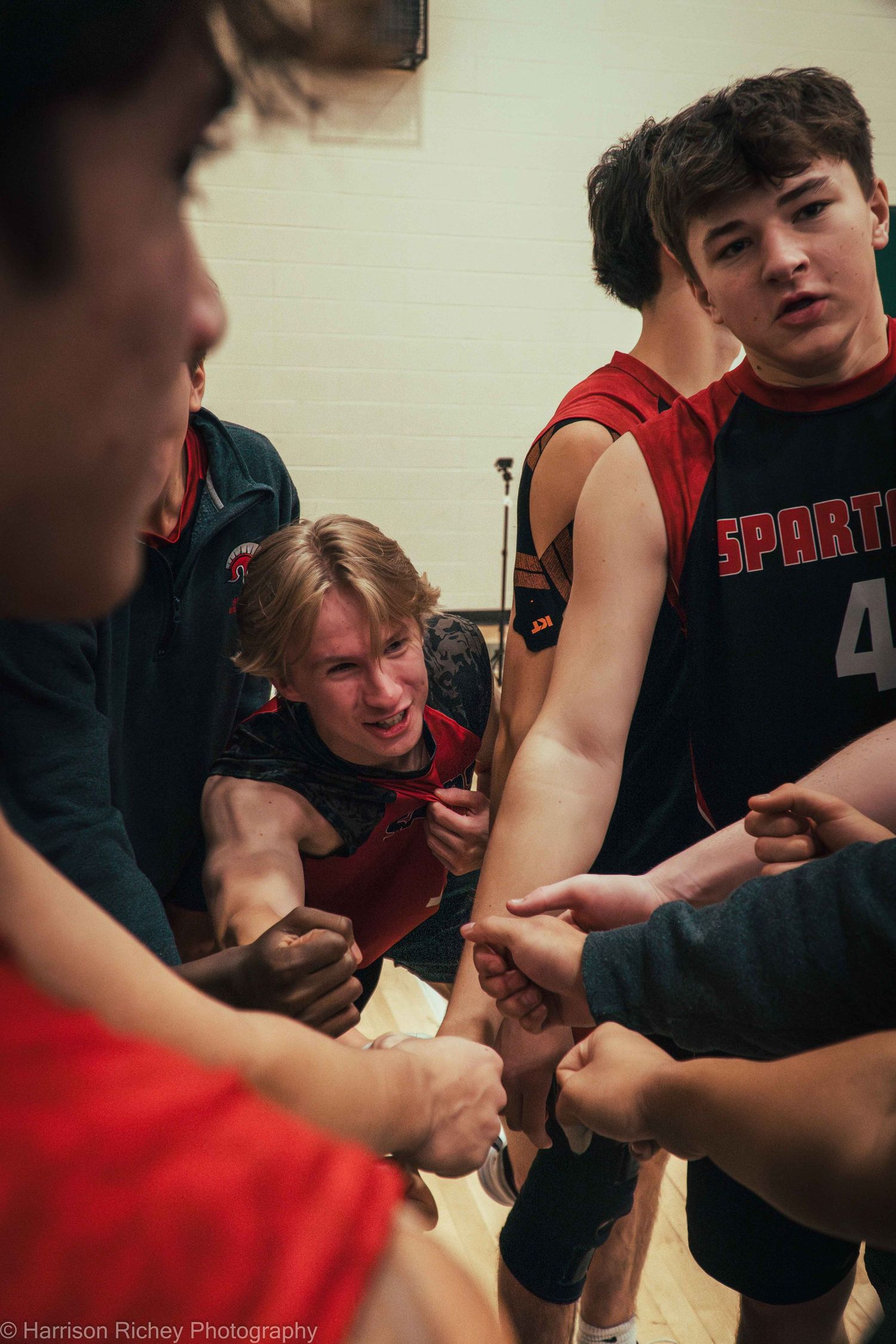 Players huddle together in red and black uniforms during a break in the game.