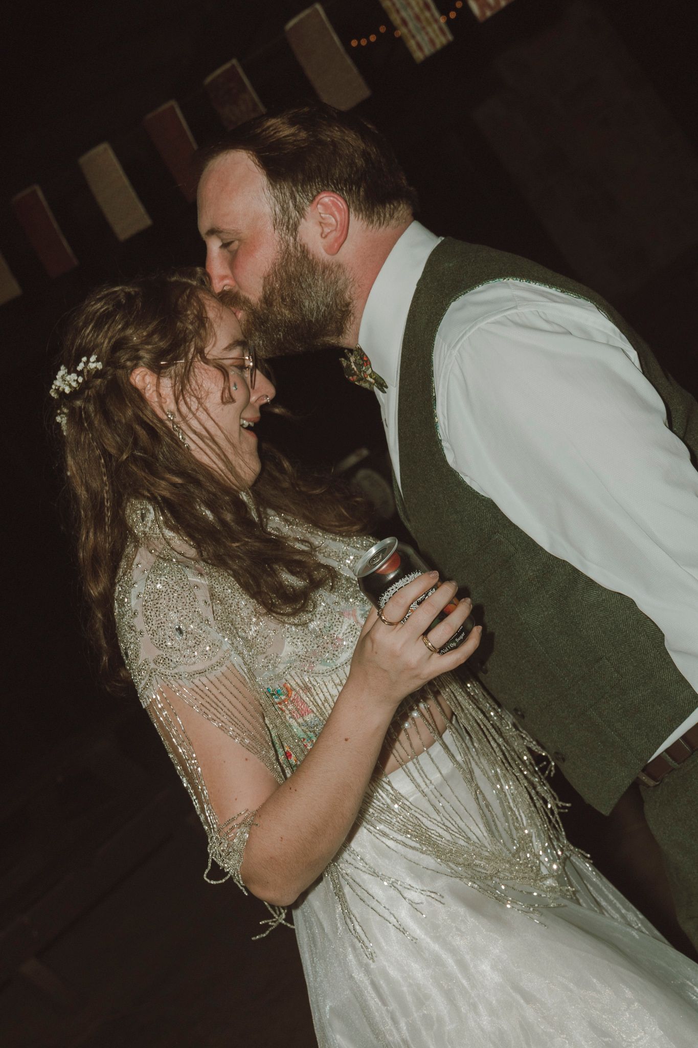 Newlyweds share a romantic dip and kiss on the dance floor during their wedding reception celebration.