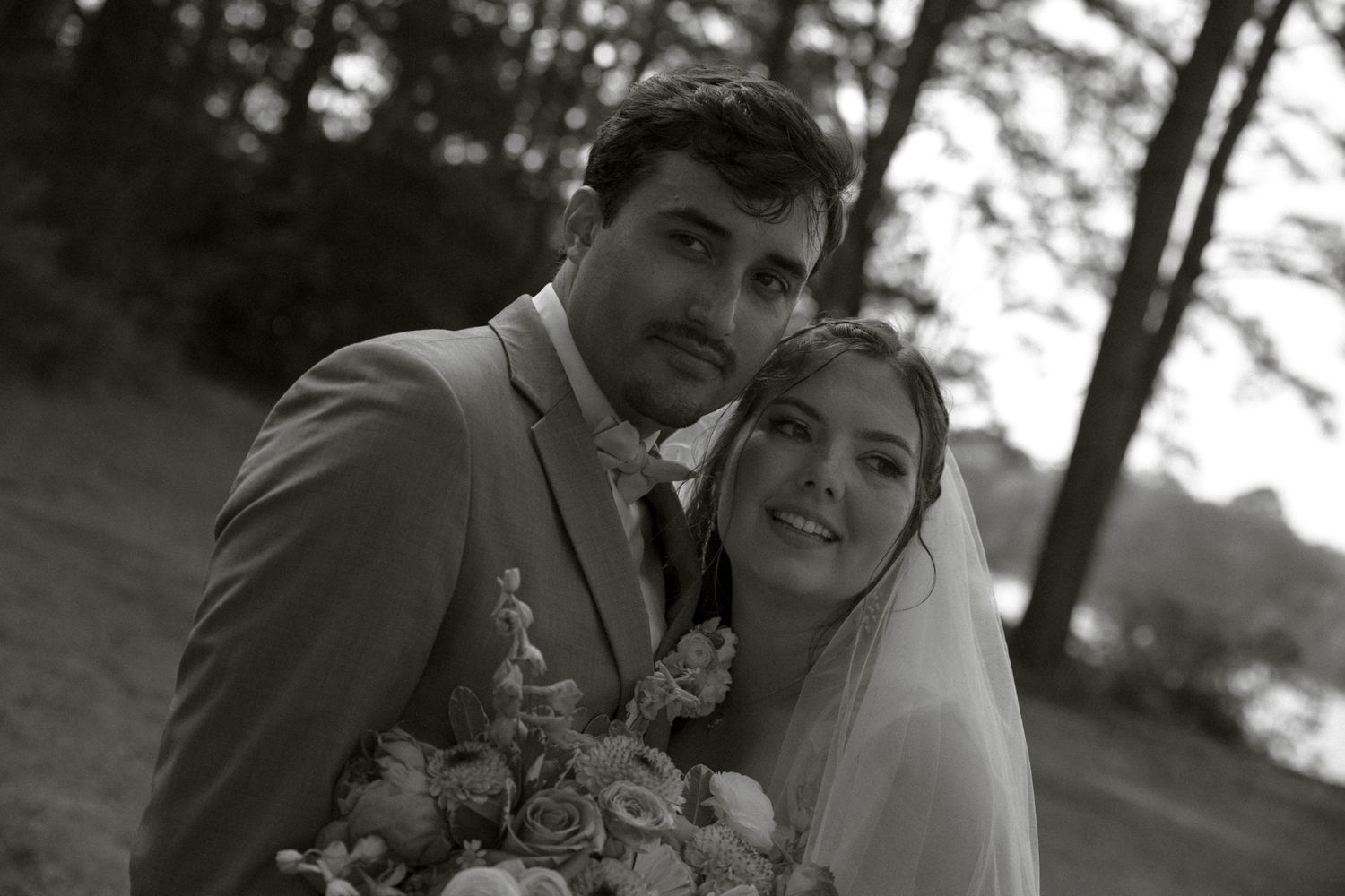 A series of black and white wedding photos showing romantic moments between a couple in a garden setting.