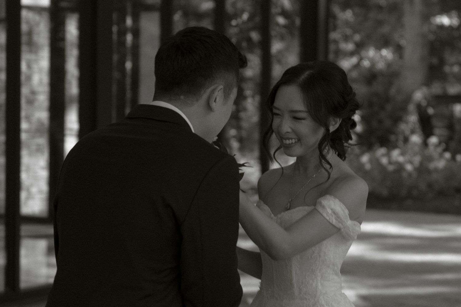 A black and white wedding photograph shows a couple dancing together at their reception celebration.