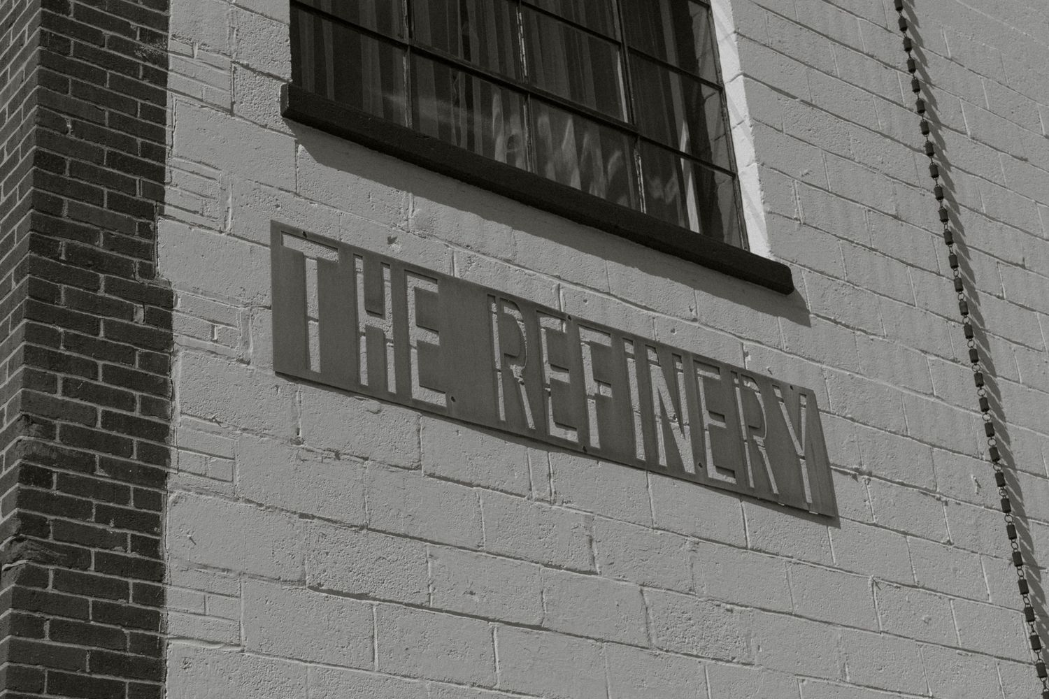 Historic brick building with 'The Refinery' text on exterior wall and multiple windows in industrial architectural style.