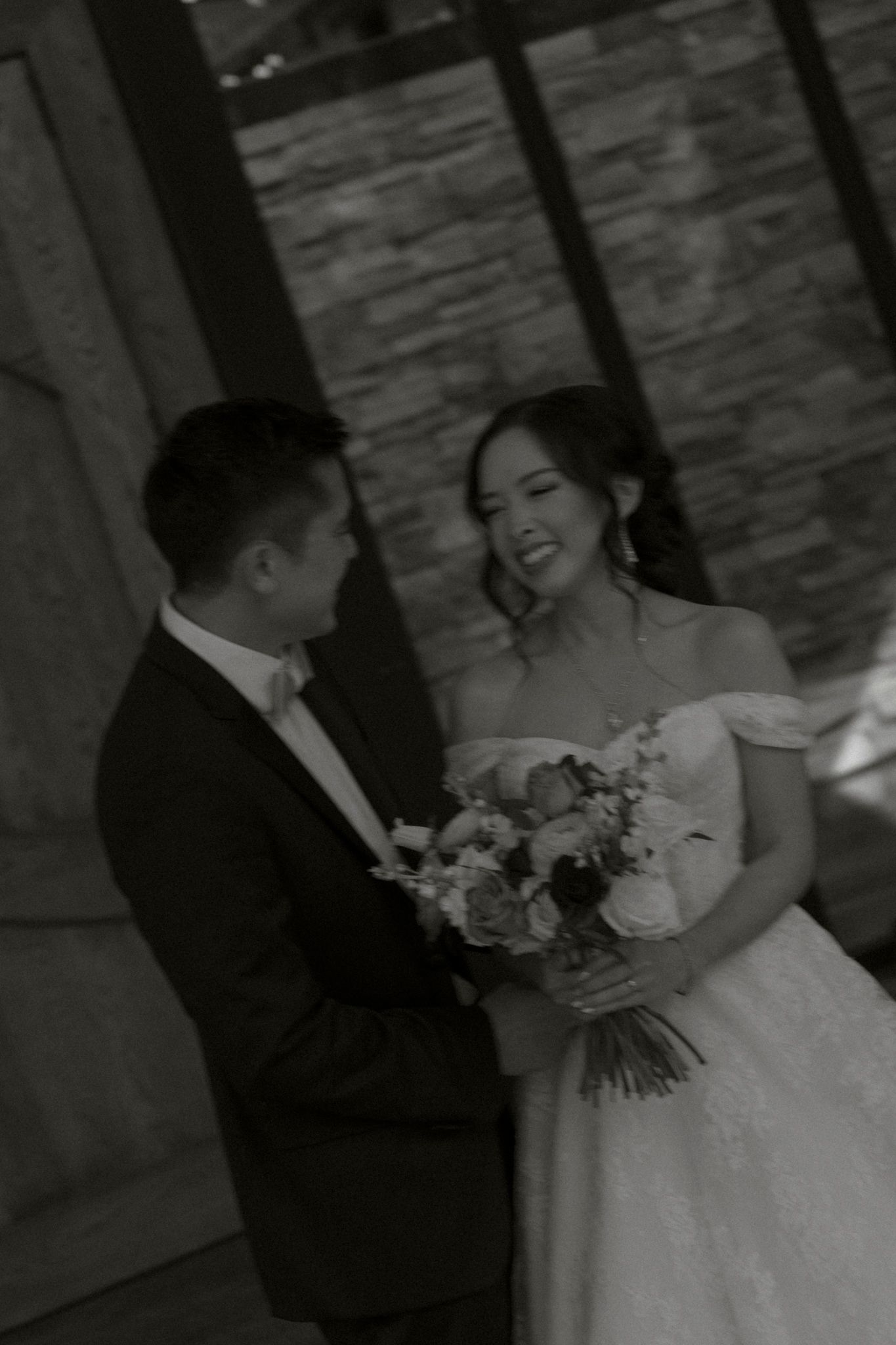 Black and white wedding photo series showing happy couple dancing and embracing during their first dance at reception.