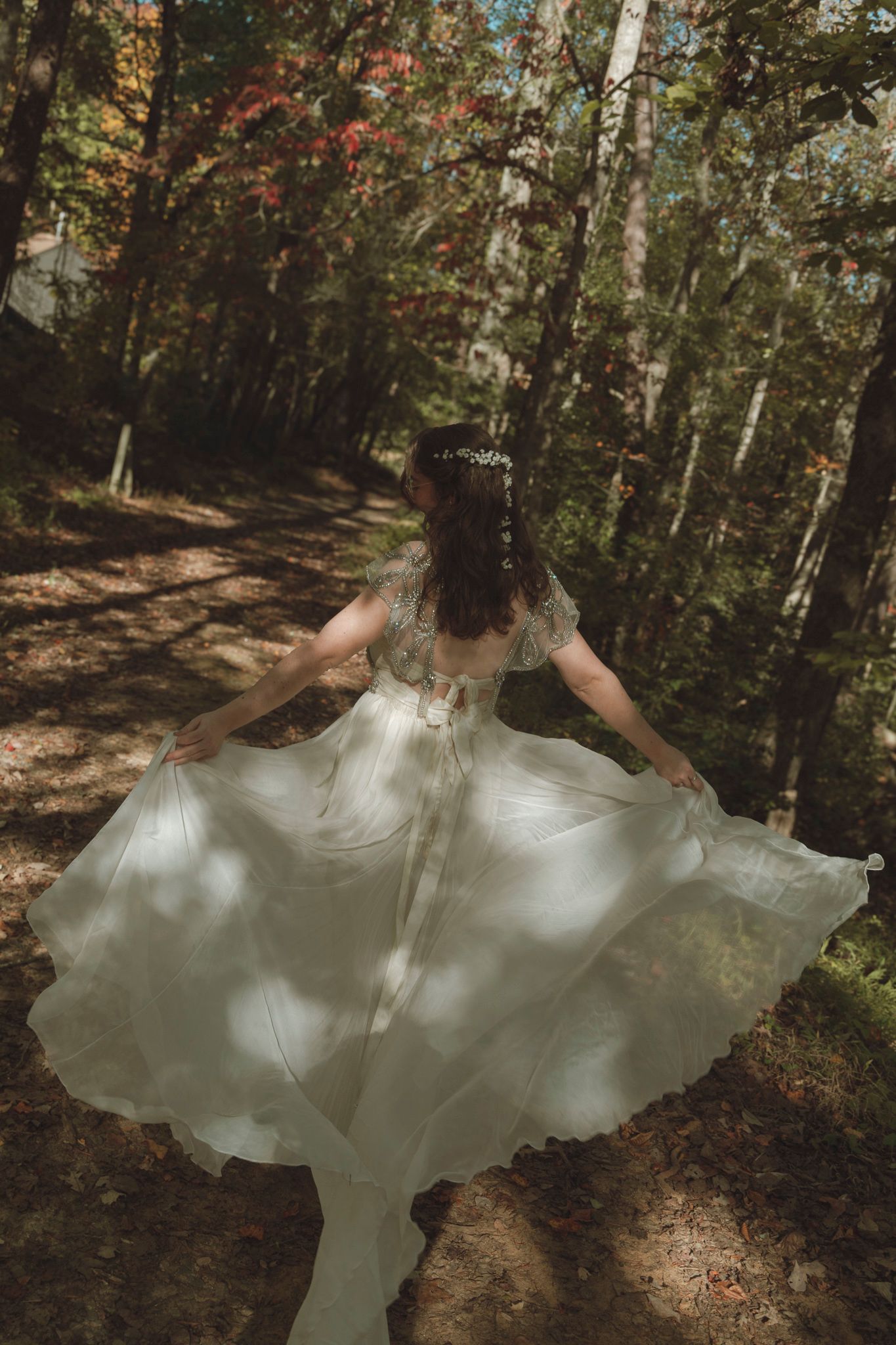 A flowing white dress twirls through autumn woods in a sequence of spinning motion photographs.