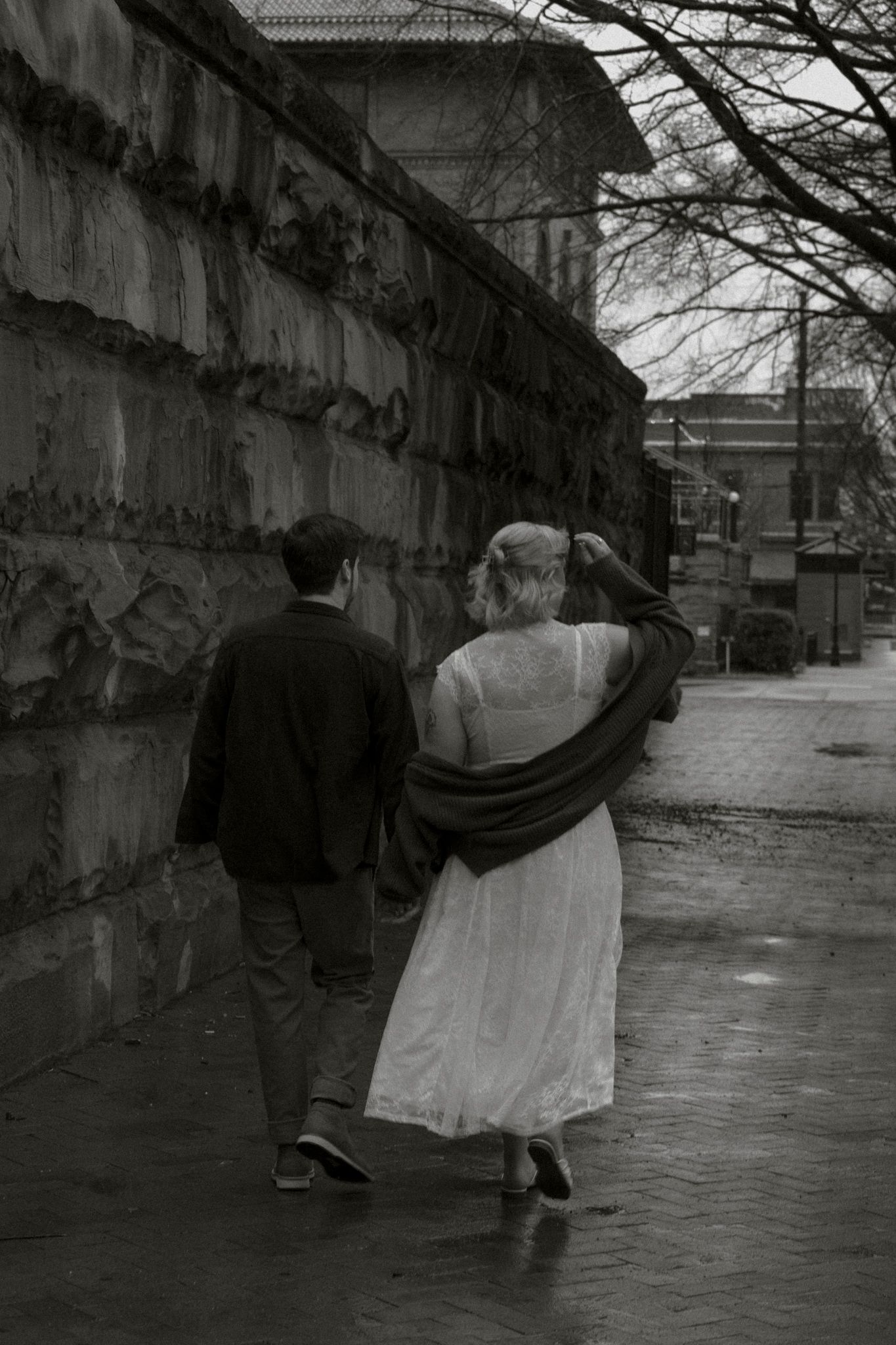 A black and white photo sequence shows two people walking behind a stone wall, creating a playful hide-and-seek effect.