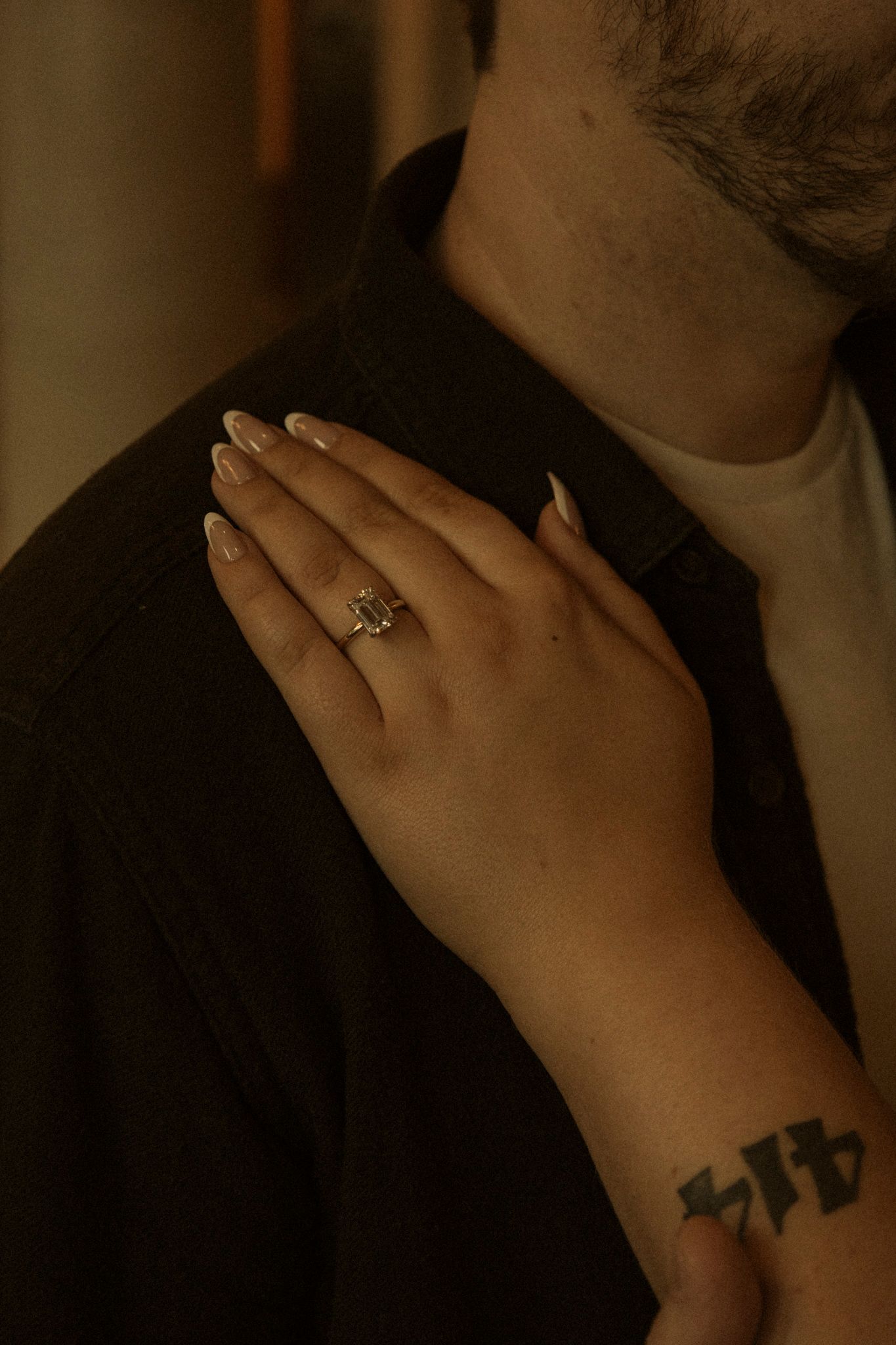 Close-up sequence showing a hand with an engagement ring and small star tattoo against a dark background.