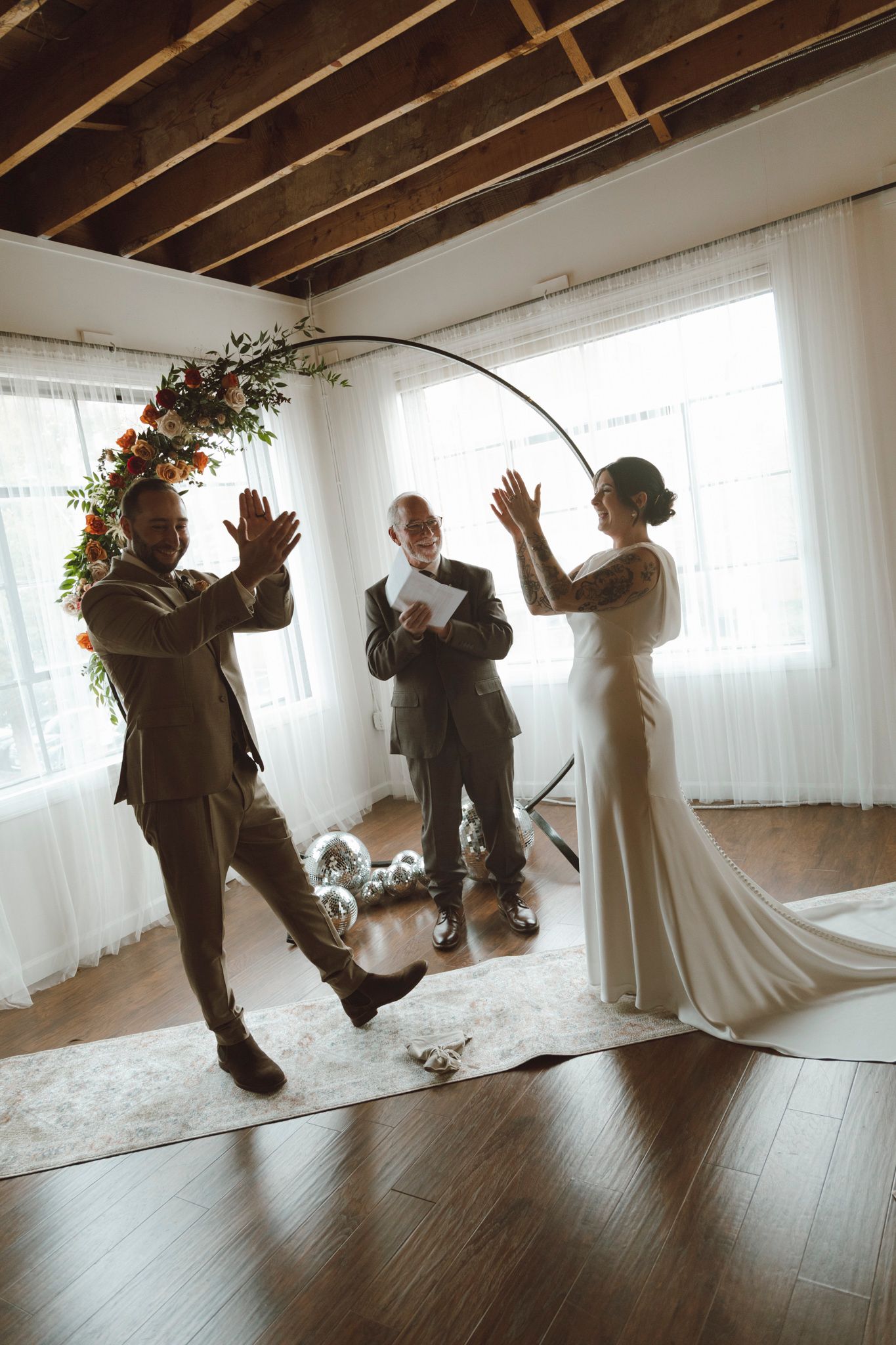 Fun action shots of wedding party members jumping and posing playfully in a bright indoor space.