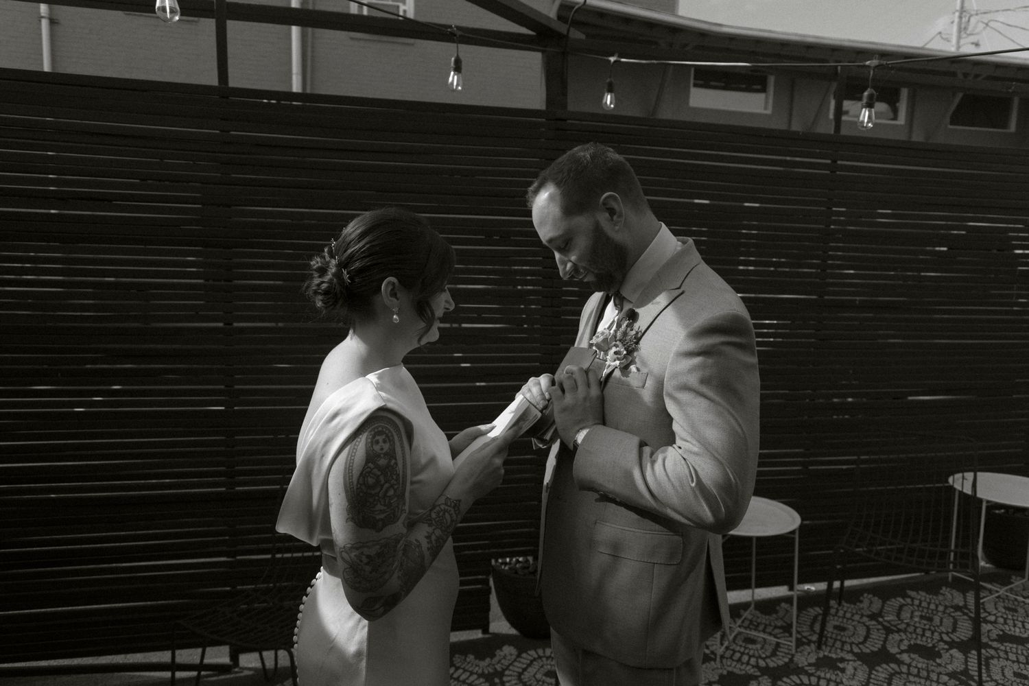 A couple in formal attire reviewing something together in empty stadium seating.