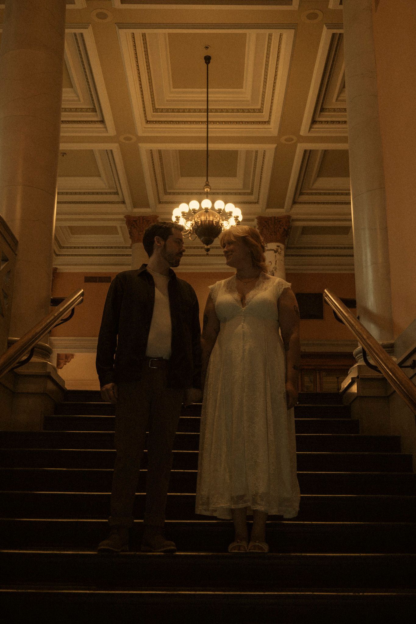 A series of wedding photos showing silhouettes of people on church steps under an elegant chandelier in a dimly lit space.