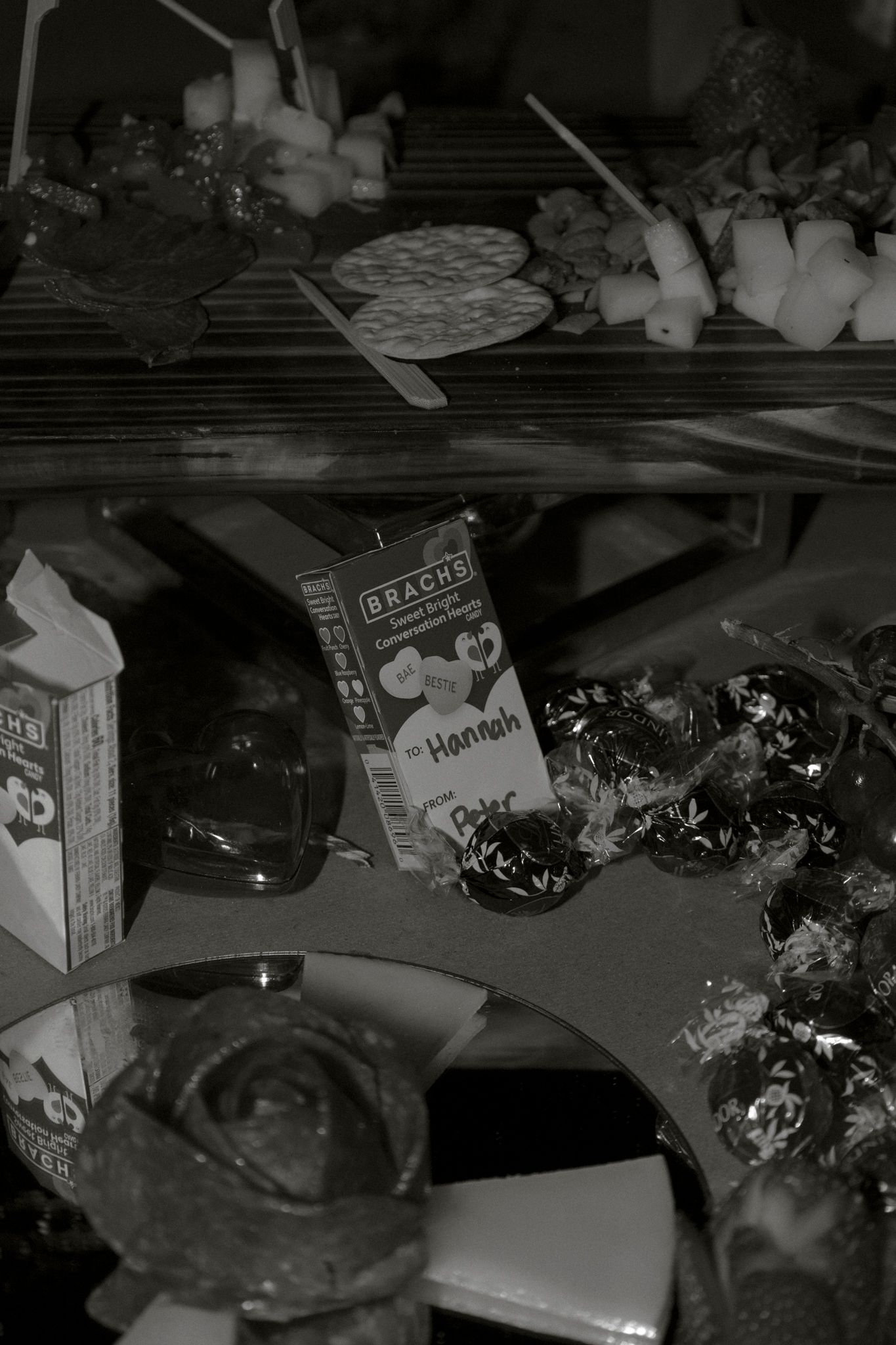 Black and white photo of a wedding candy table with Brachs chocolates, treats, and a name card reading Hannah.