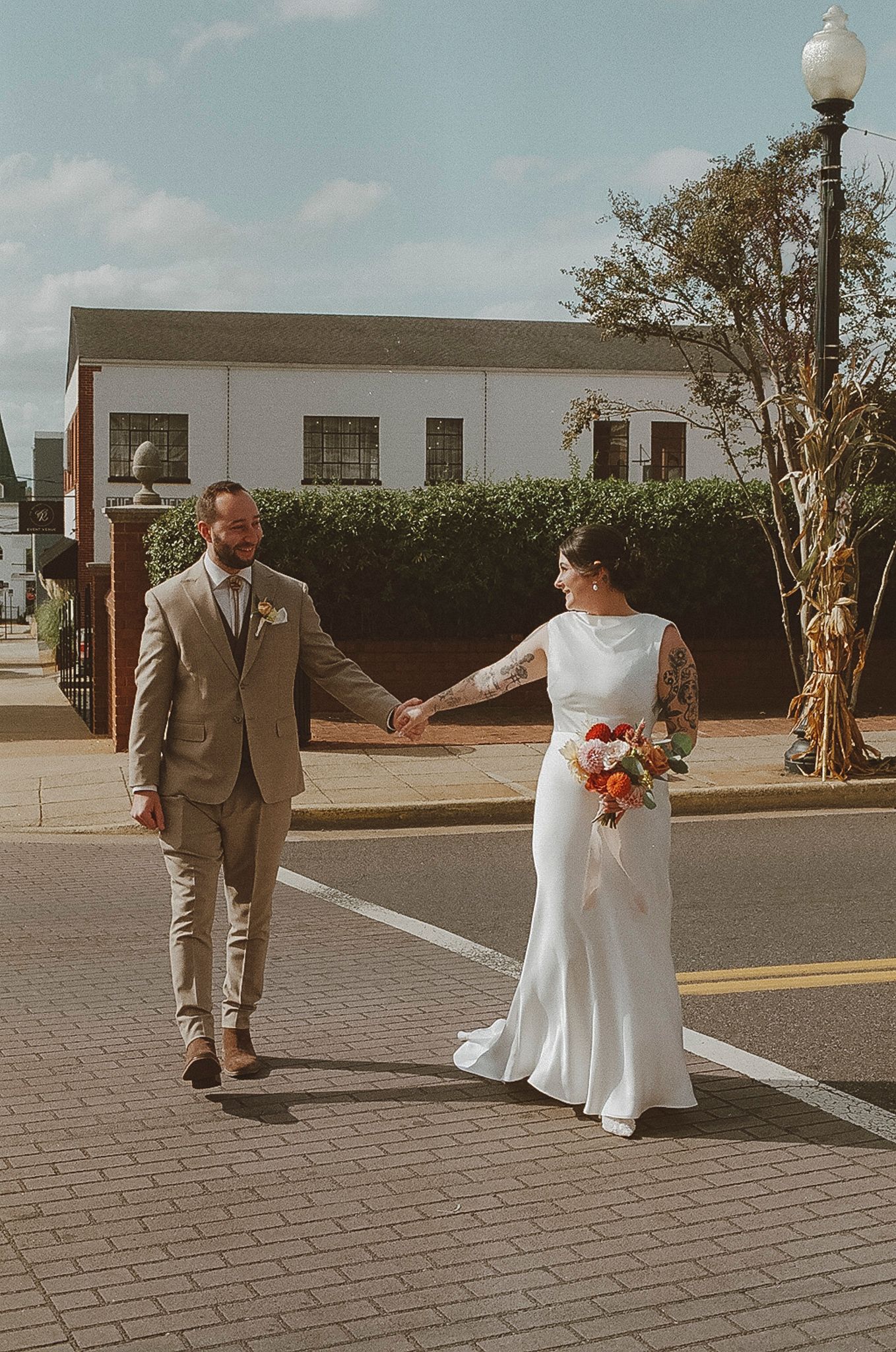 A couple in wedding attire share a first look moment on a brick paved courtyard during their special day.