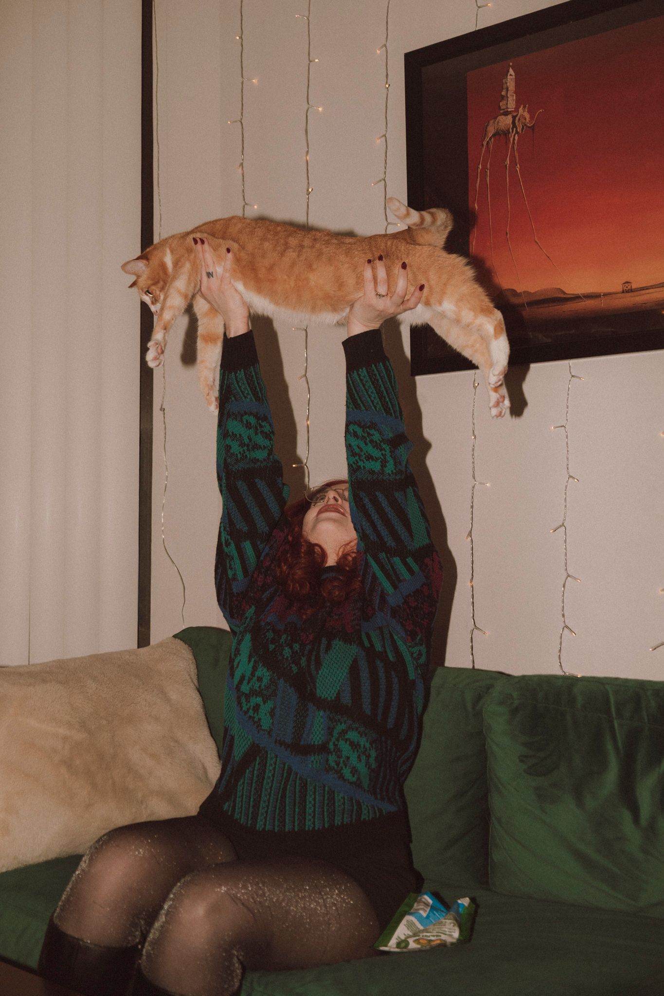 A sequence of photos shows a cat jumping and landing on someone sitting on a green couch.