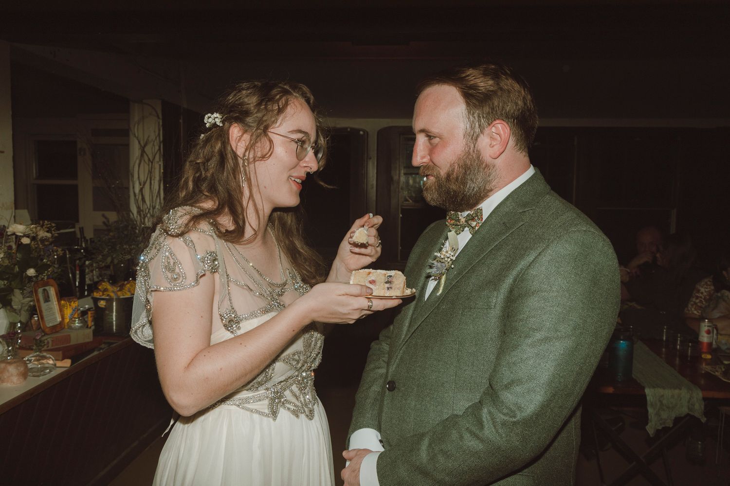 A couple shares a romantic dance together at a dimly lit wedding reception.