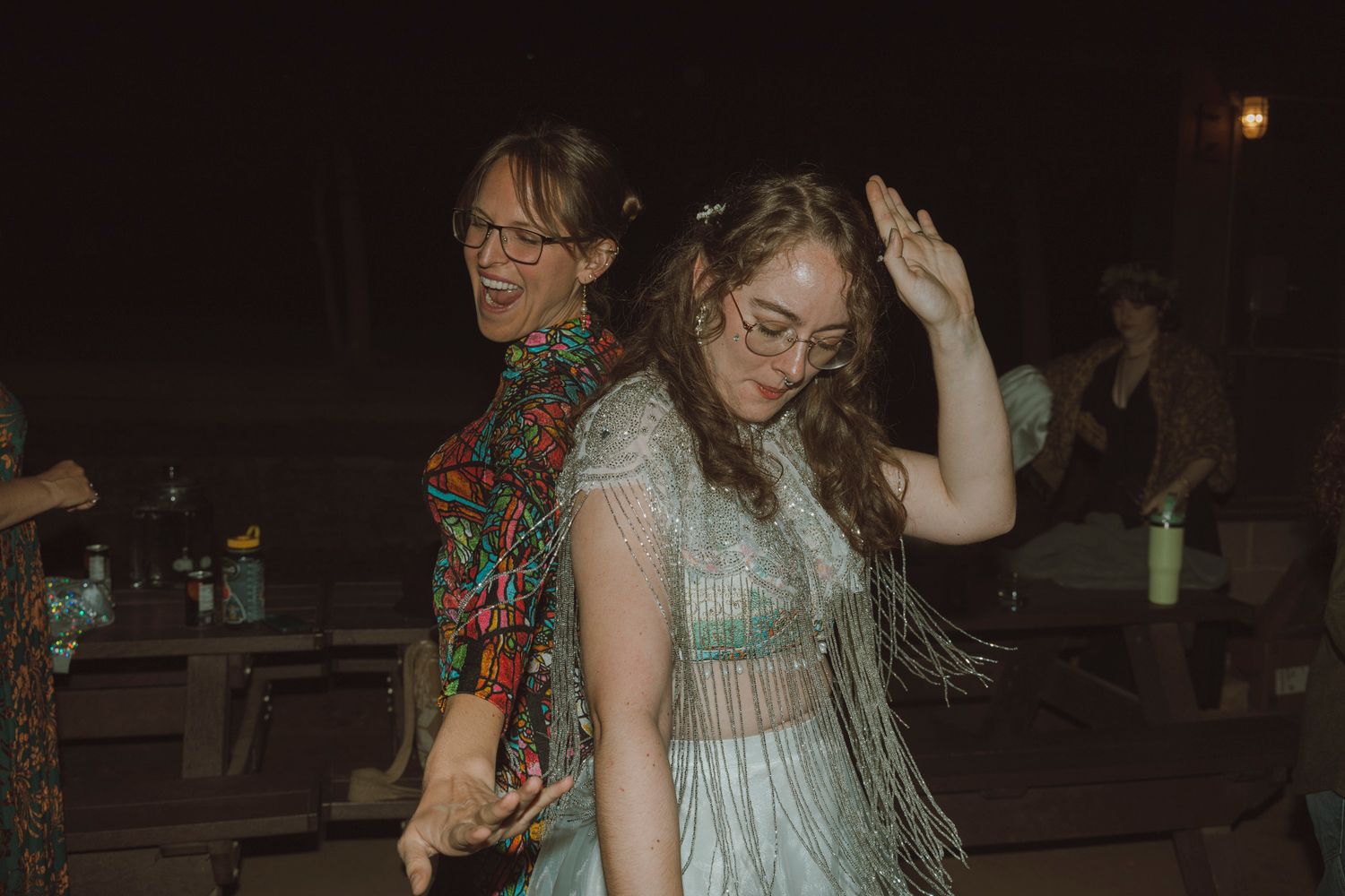 A group of people dancing and enjoying themselves at a dimly lit party or social gathering.