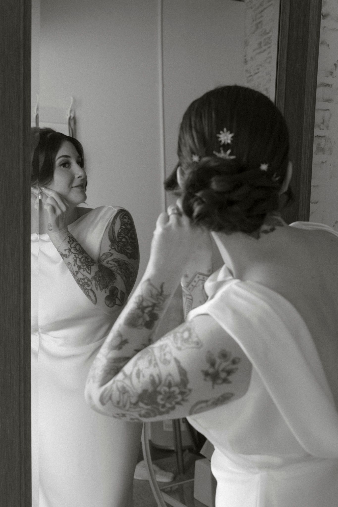A series of black and white photos showing someone in a white dress looking in a mirror.