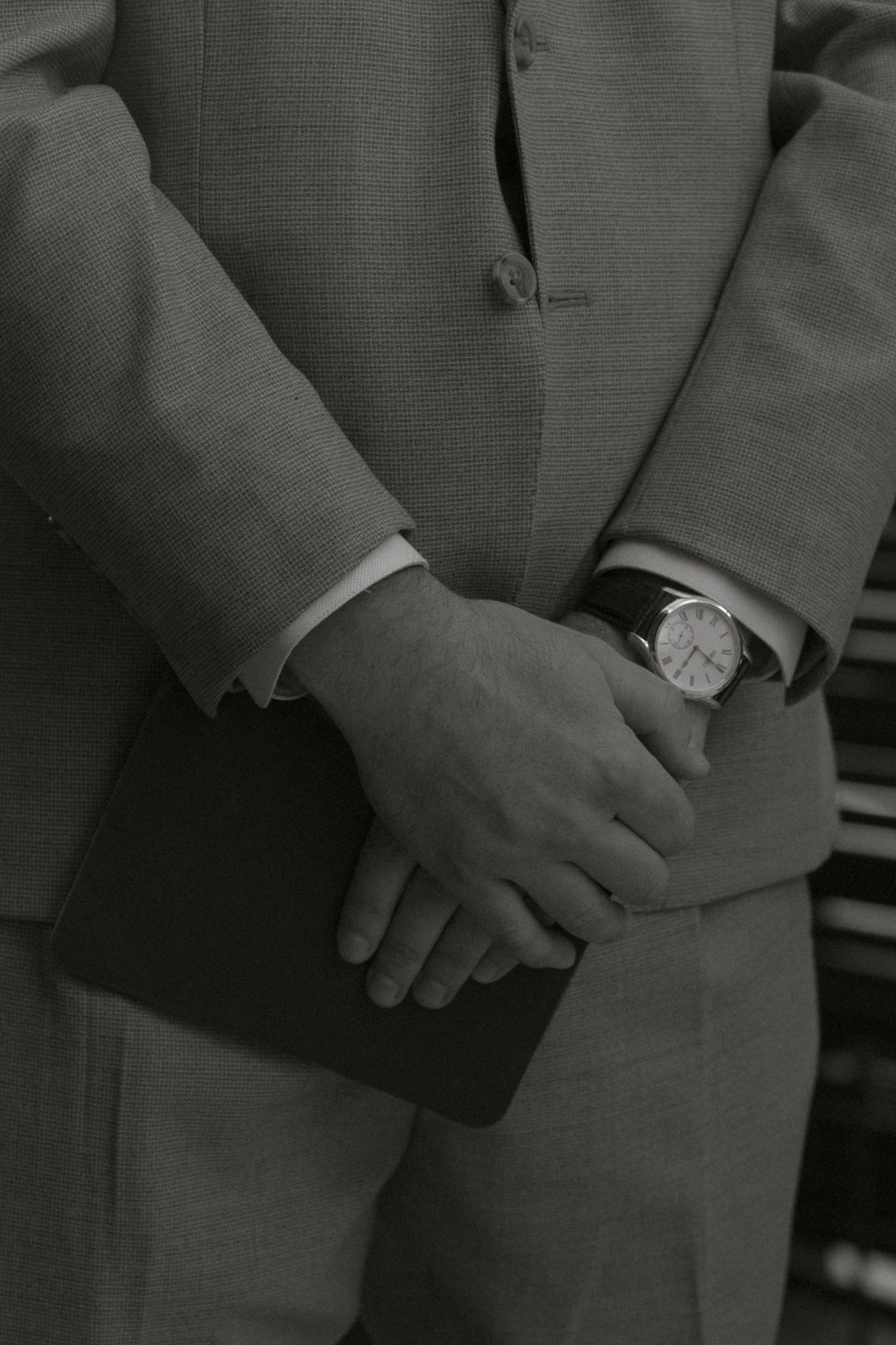 Close-up sequence of hands holding each other in formal wedding attire.