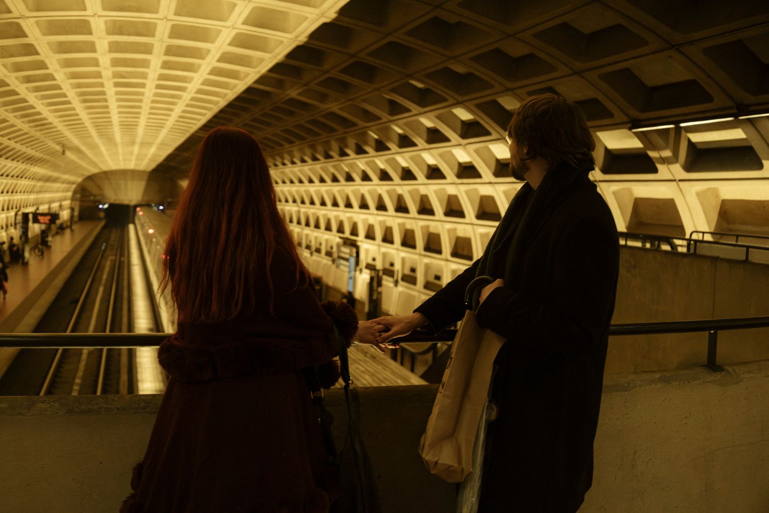 Metro station platform with curved tunnel ceiling and warm lighting creating symmetrical architectural patterns.