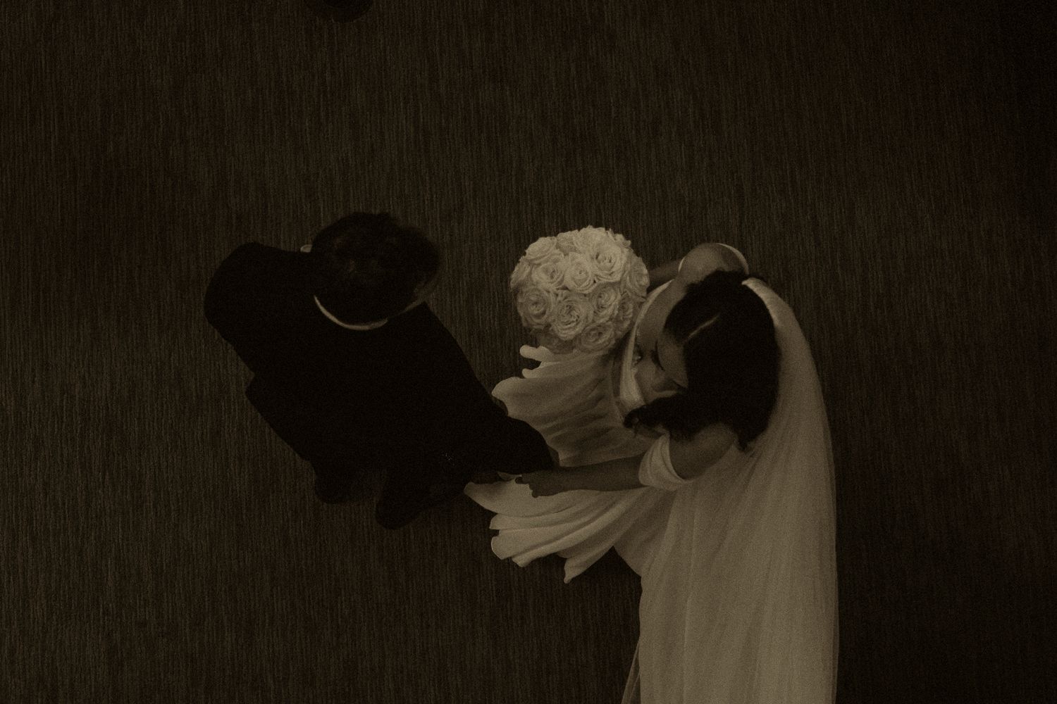 Aerial view of a bride and groom sharing a romantic moment at their wedding ceremony.