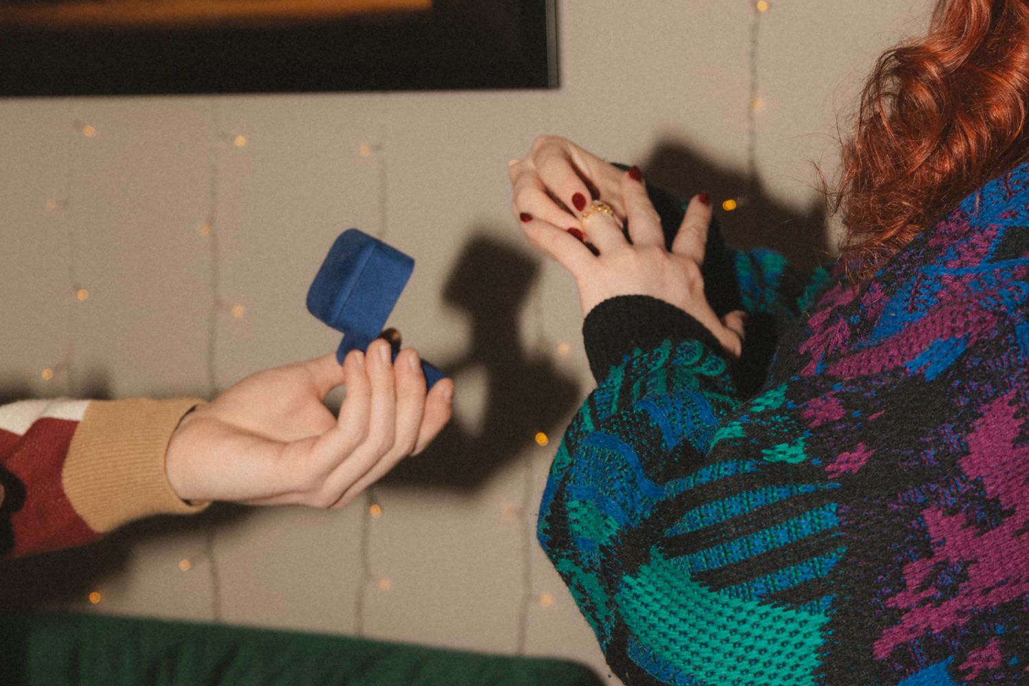 A close-up sequence showing hands knitting with colorful teal and purple yarn using knitting needles.