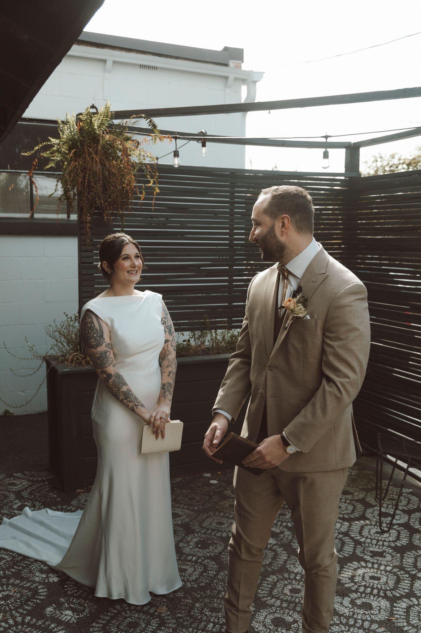 Couple in wedding attire sharing intimate moments on an outdoor rooftop patio.
