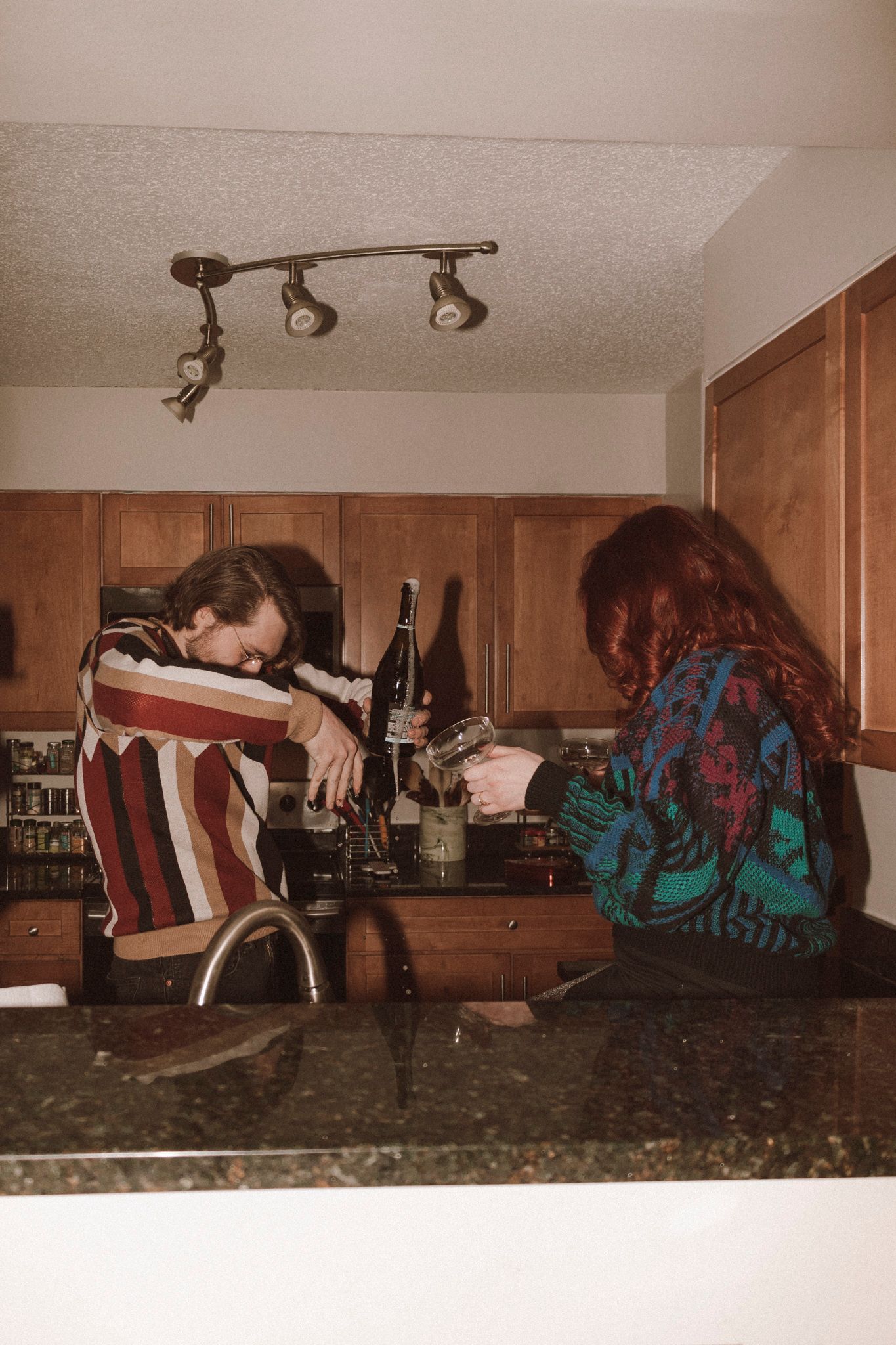 A sequence of photos showing someone crawling across a kitchen counter from left to right with a dark patterned jacket.