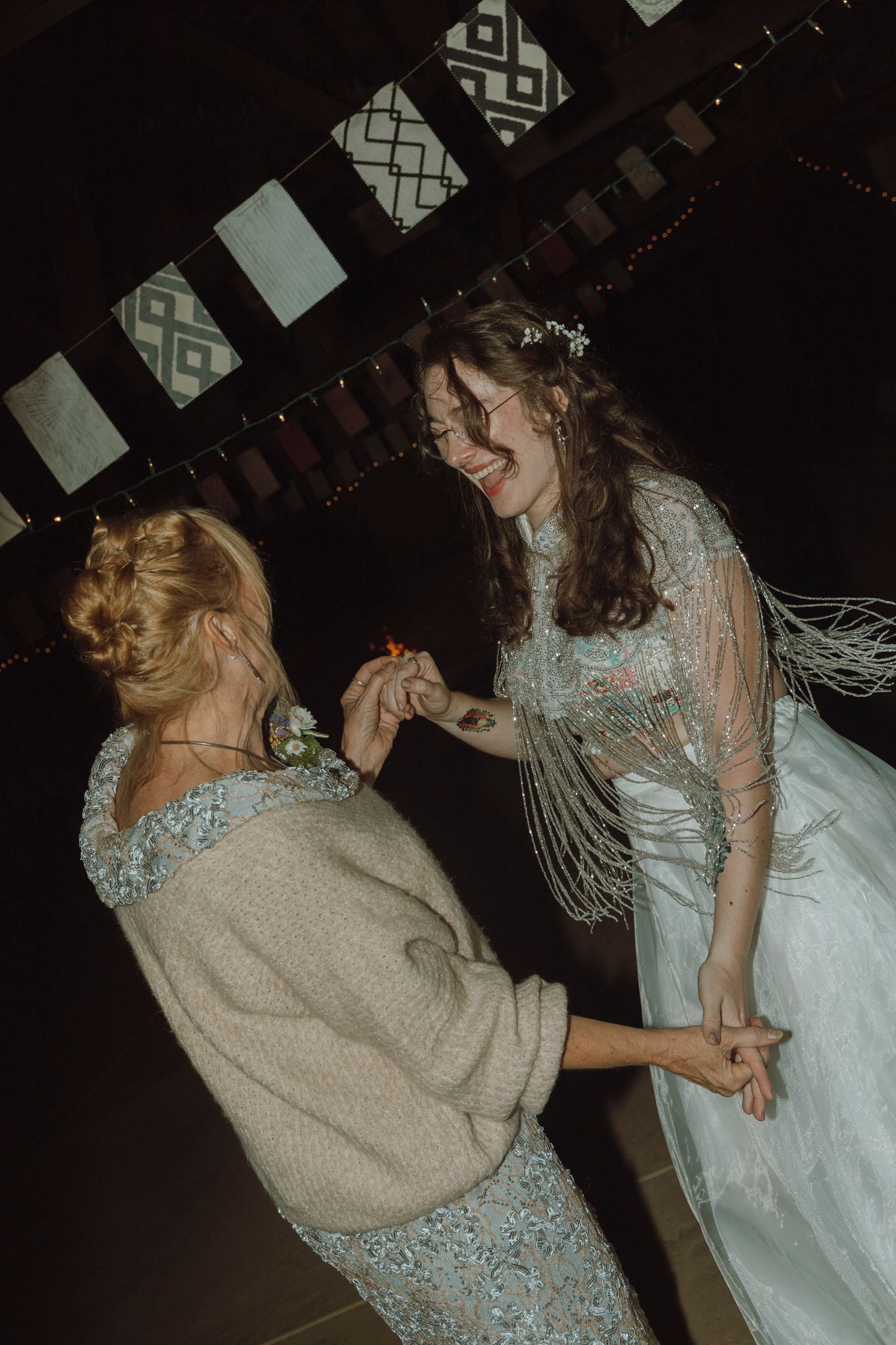 Two people dancing together in formal attire at a dimly lit venue.